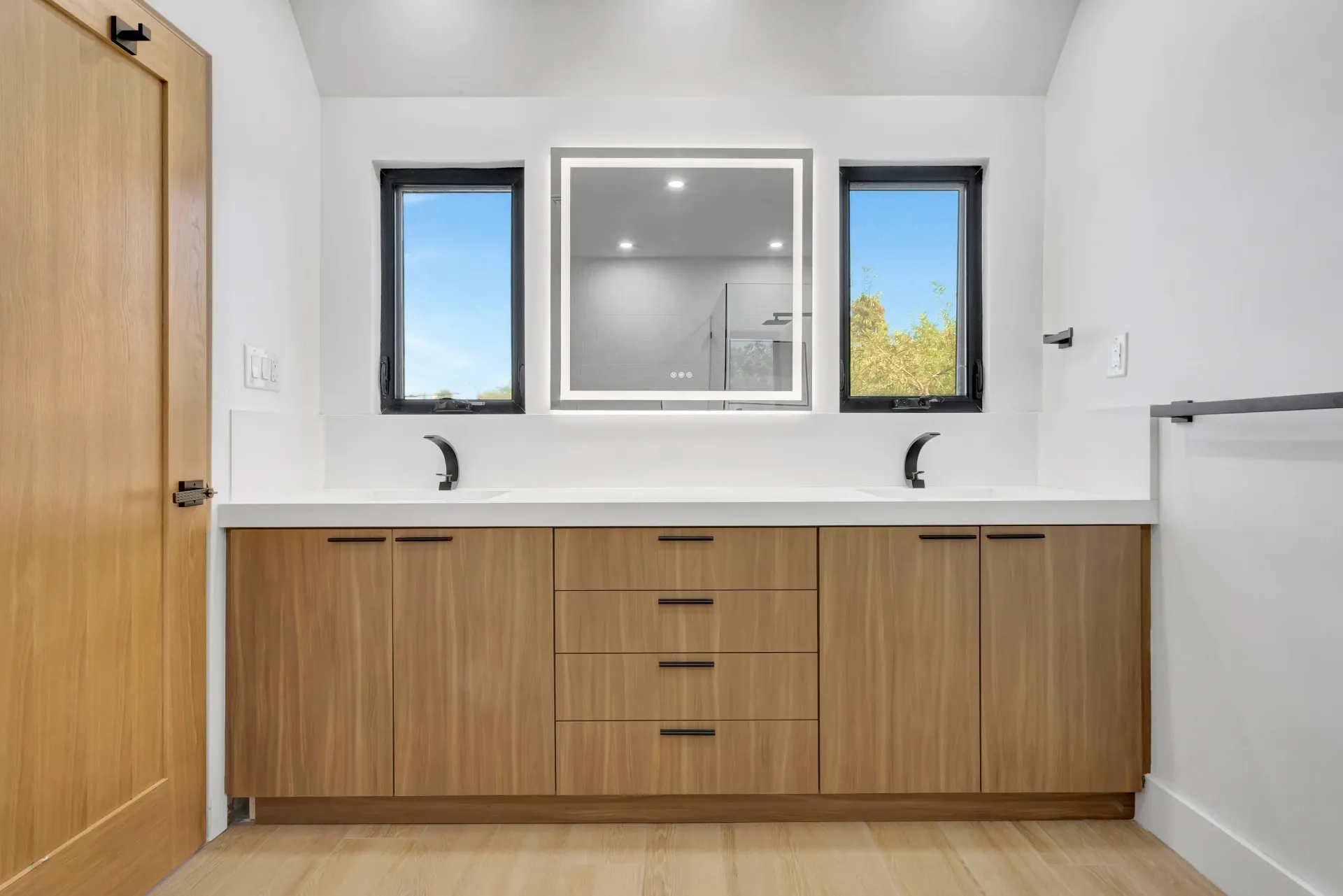 1145 S Longwood Ave Mid-Wilshire — Bathroom: Dual vanity bathroom with wood cabinetry and illuminated mirrors