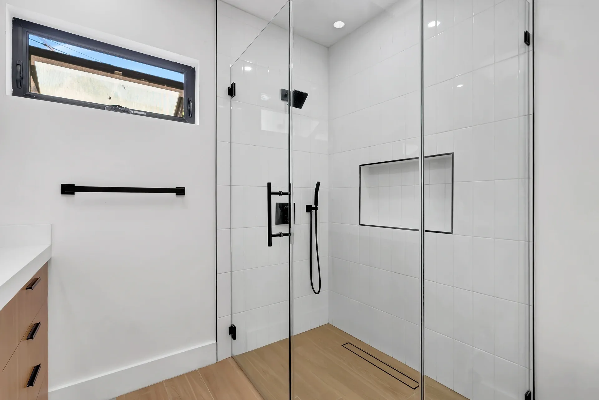 1145 S Longwood Ave Mid-Wilshire — Bathroom: Glass shower enclosure with white tile and black fixtures