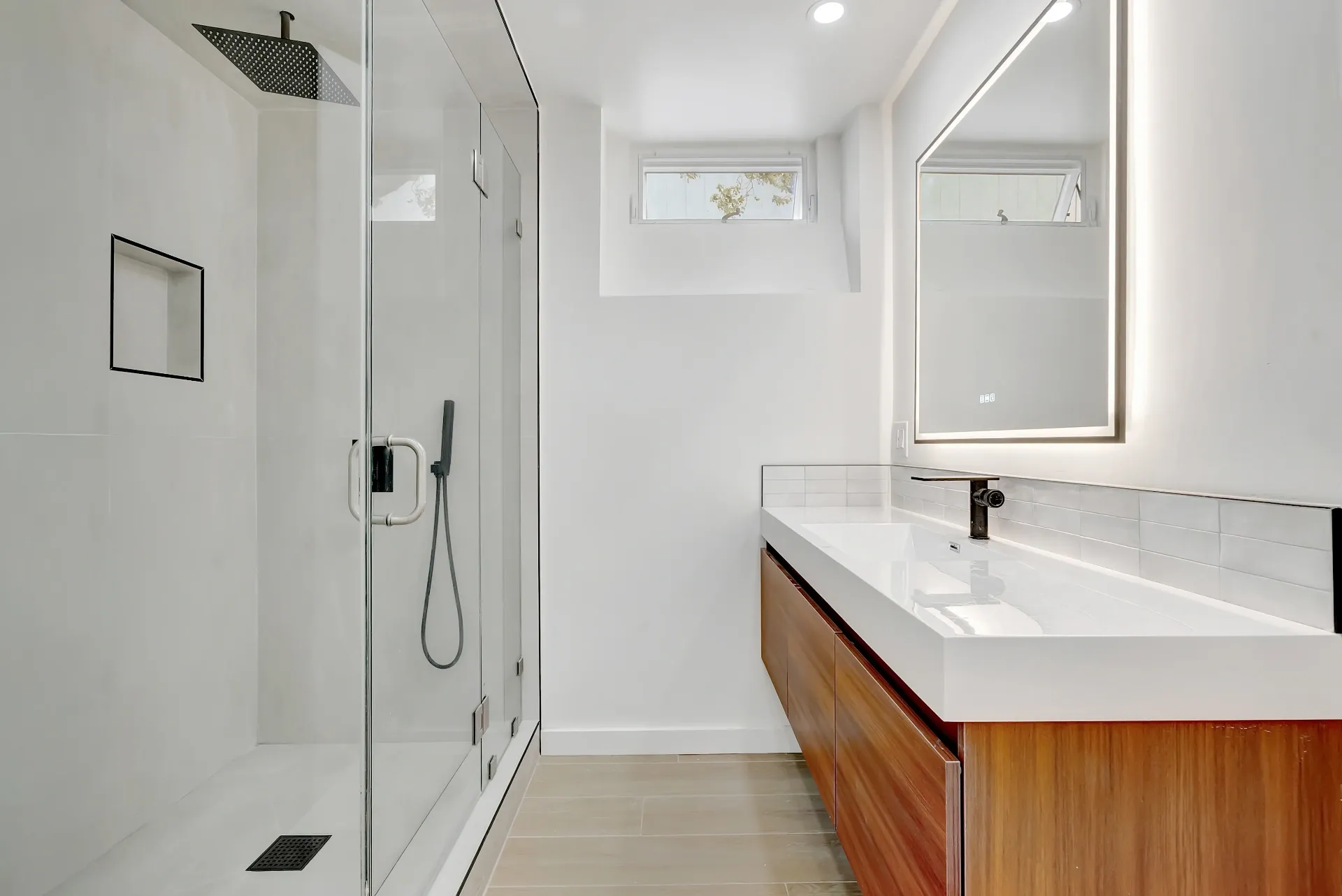 1145 S Longwood Ave Mid-Wilshire — Bathroom: Contemporary bathroom with wood vanity, glass shower, and natural light