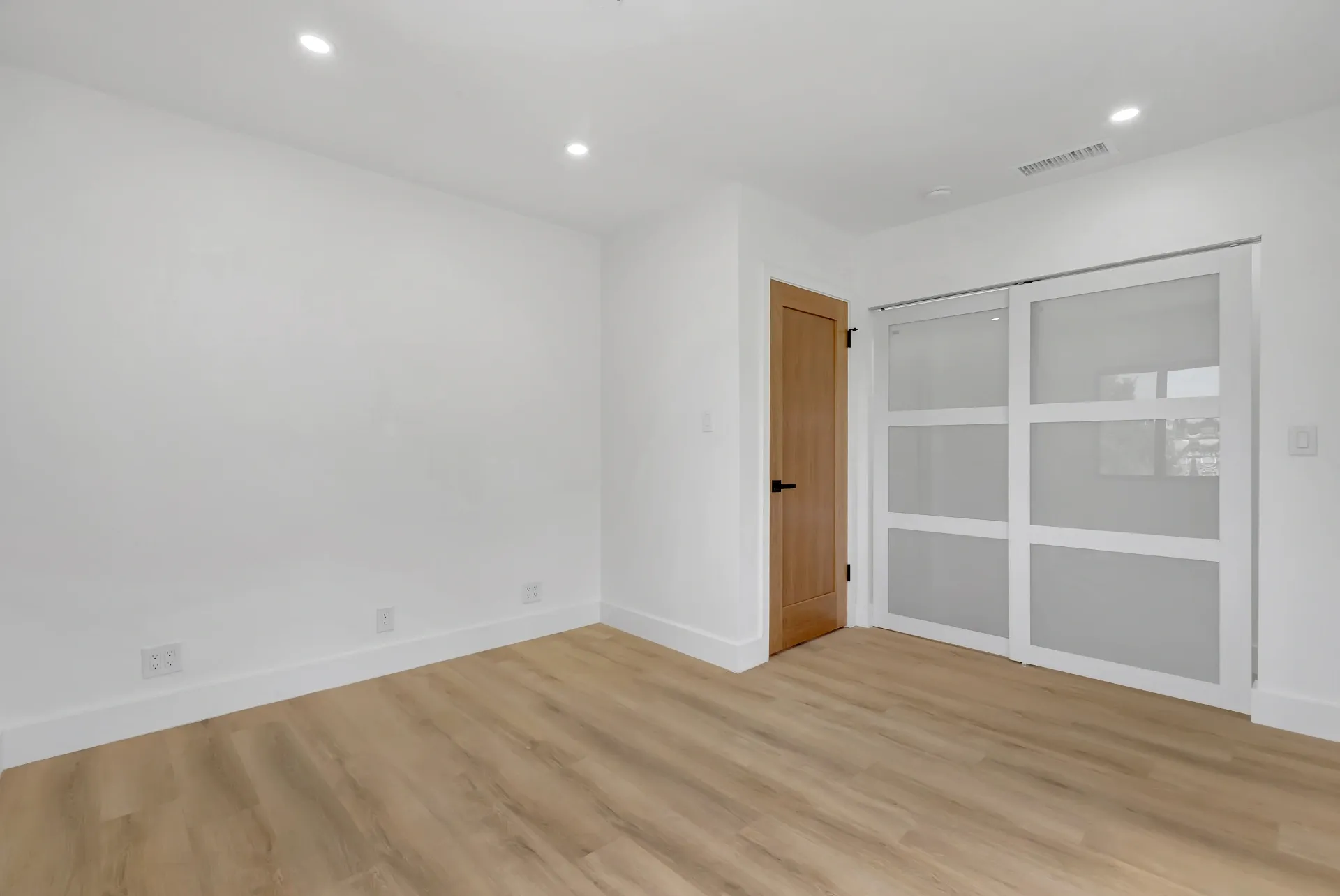 1145 S Longwood Ave Mid-Wilshire — Bedroom: Bedroom with built-in closet and modern glass doors