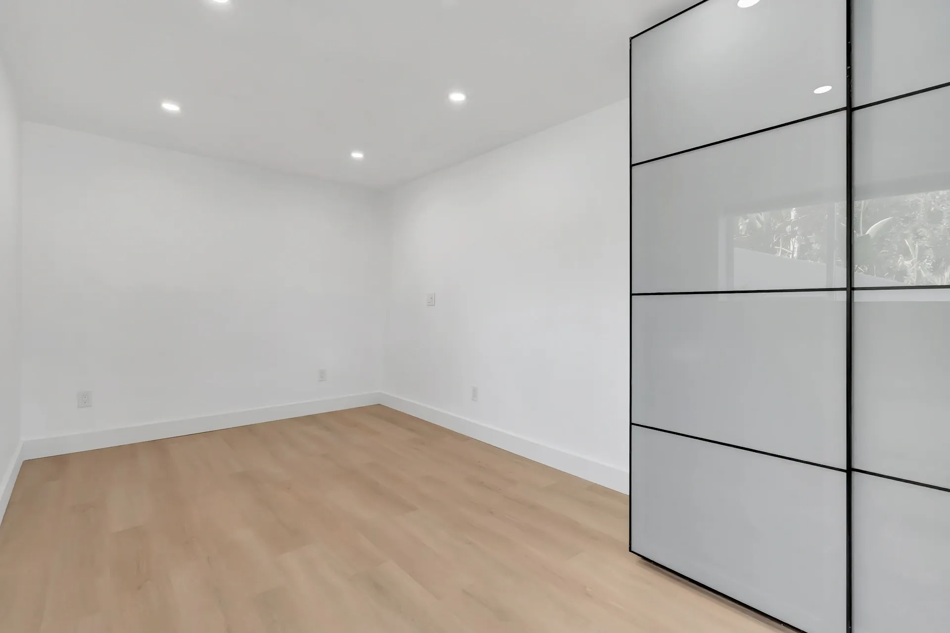 1145 S Longwood Ave Mid-Wilshire — Bedroom: Minimalist bedroom with sleek built-in wardrobes and clean lines
