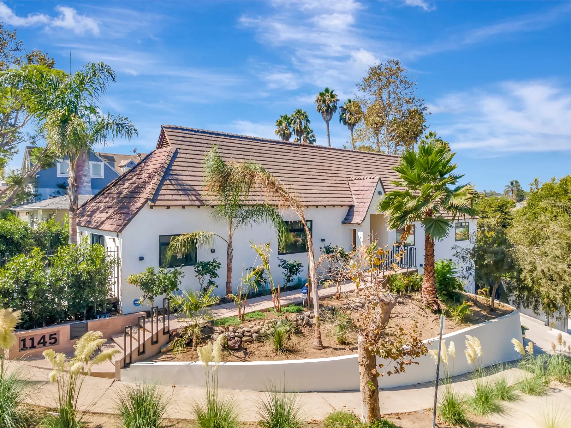 1145 S Longwood Ave Mid-Wilshire — Exterior: Front exterior view showing white stucco facade and sculptural landscaping
