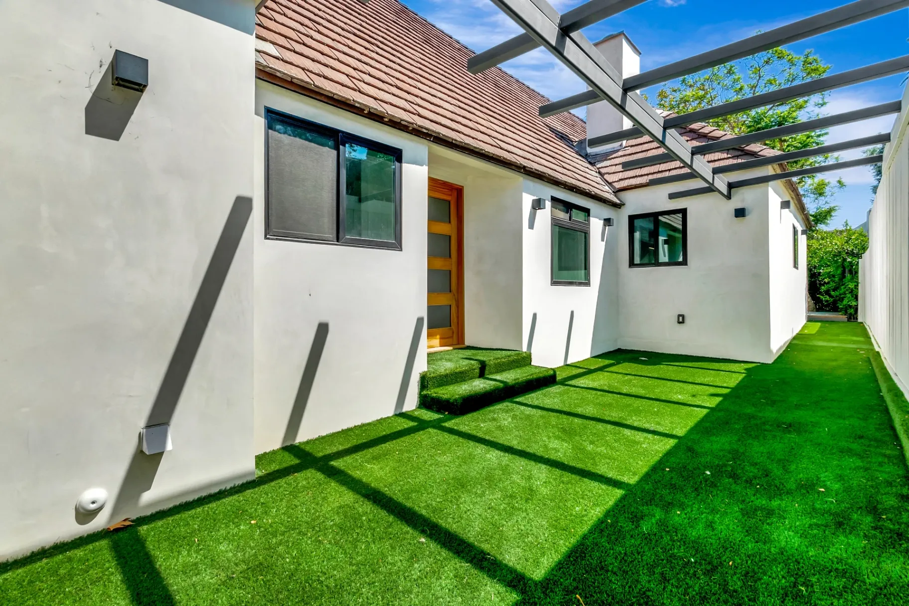 1145 S Longwood Ave Mid-Wilshire — Exterior: Side yard with artificial turf and modern patio design
