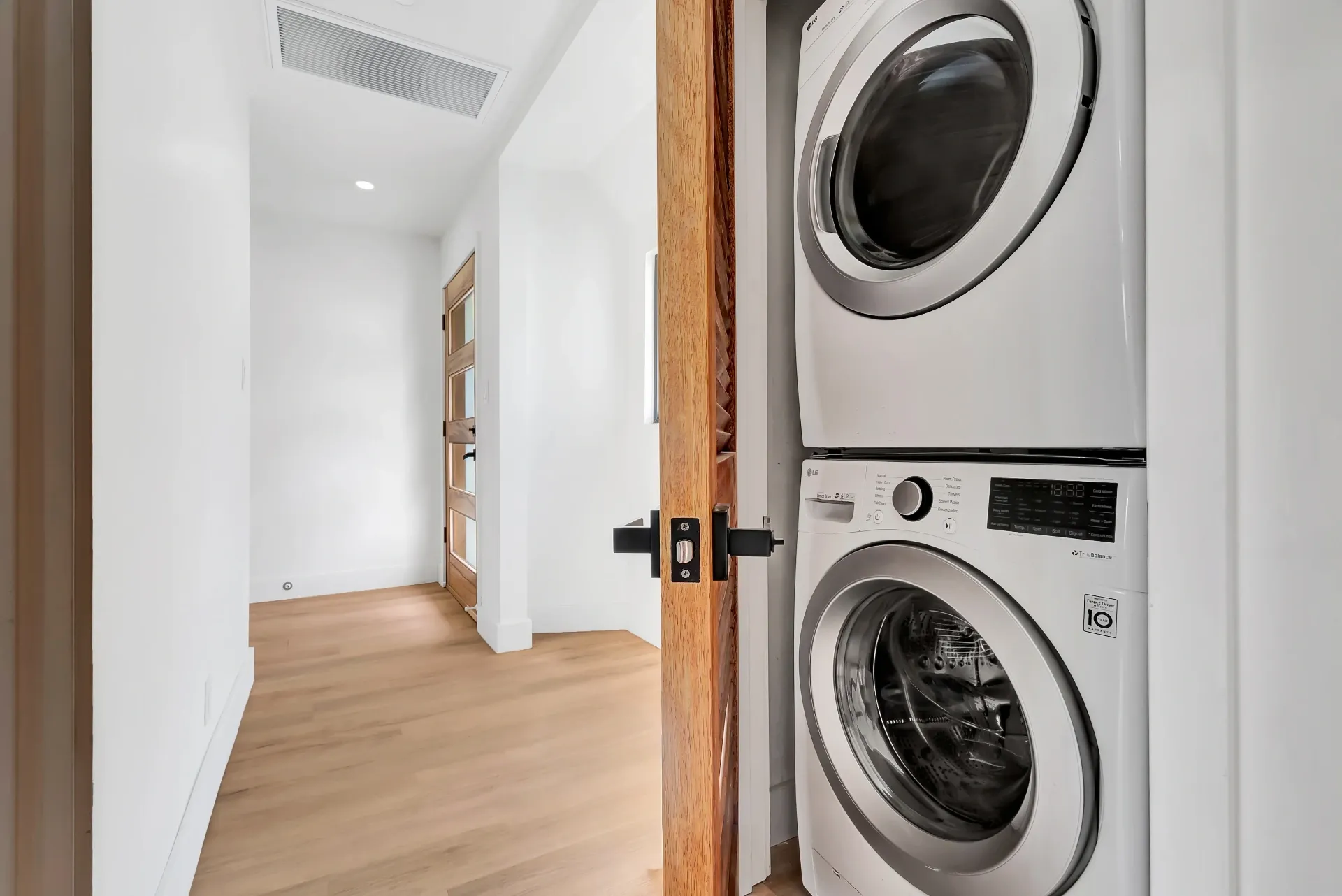 1145 S Longwood Ave Mid-Wilshire — Living: Laundry room with stacked washer and dryer and wood flooring