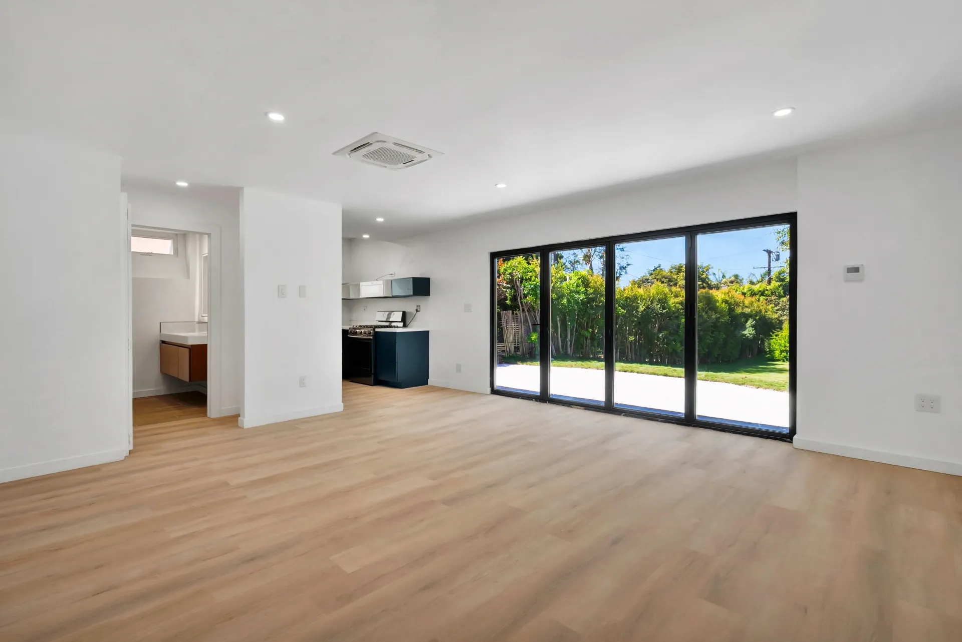 1145 S Longwood Ave Mid-Wilshire — Living: Open floor plan with kitchen view and sliding glass doors to backyard