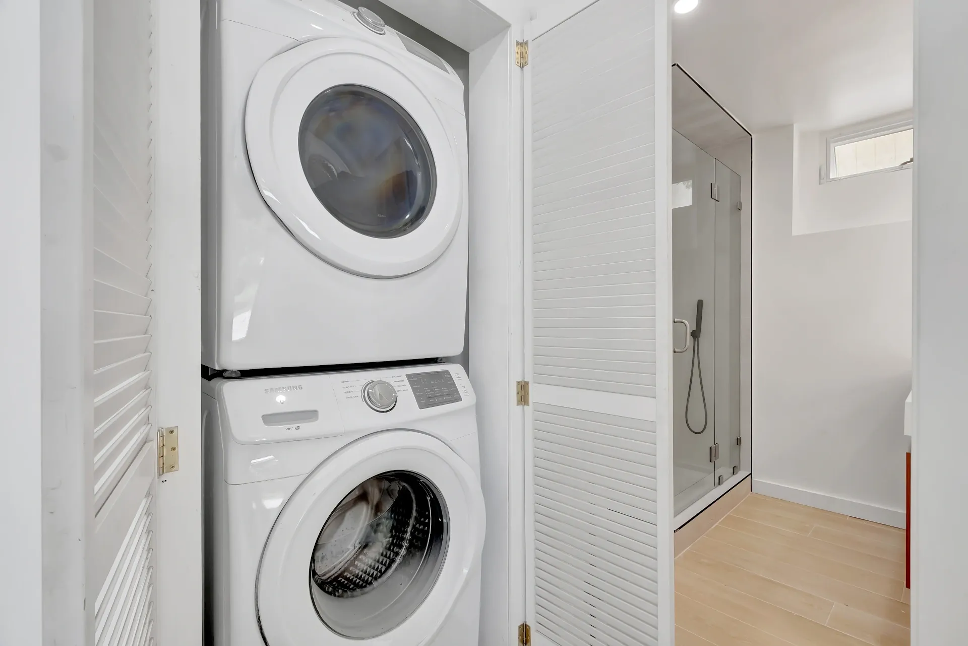 1145 S Longwood Ave Mid-Wilshire — Living: Utility room with stacked Samsung washer and dryer and louvered storage