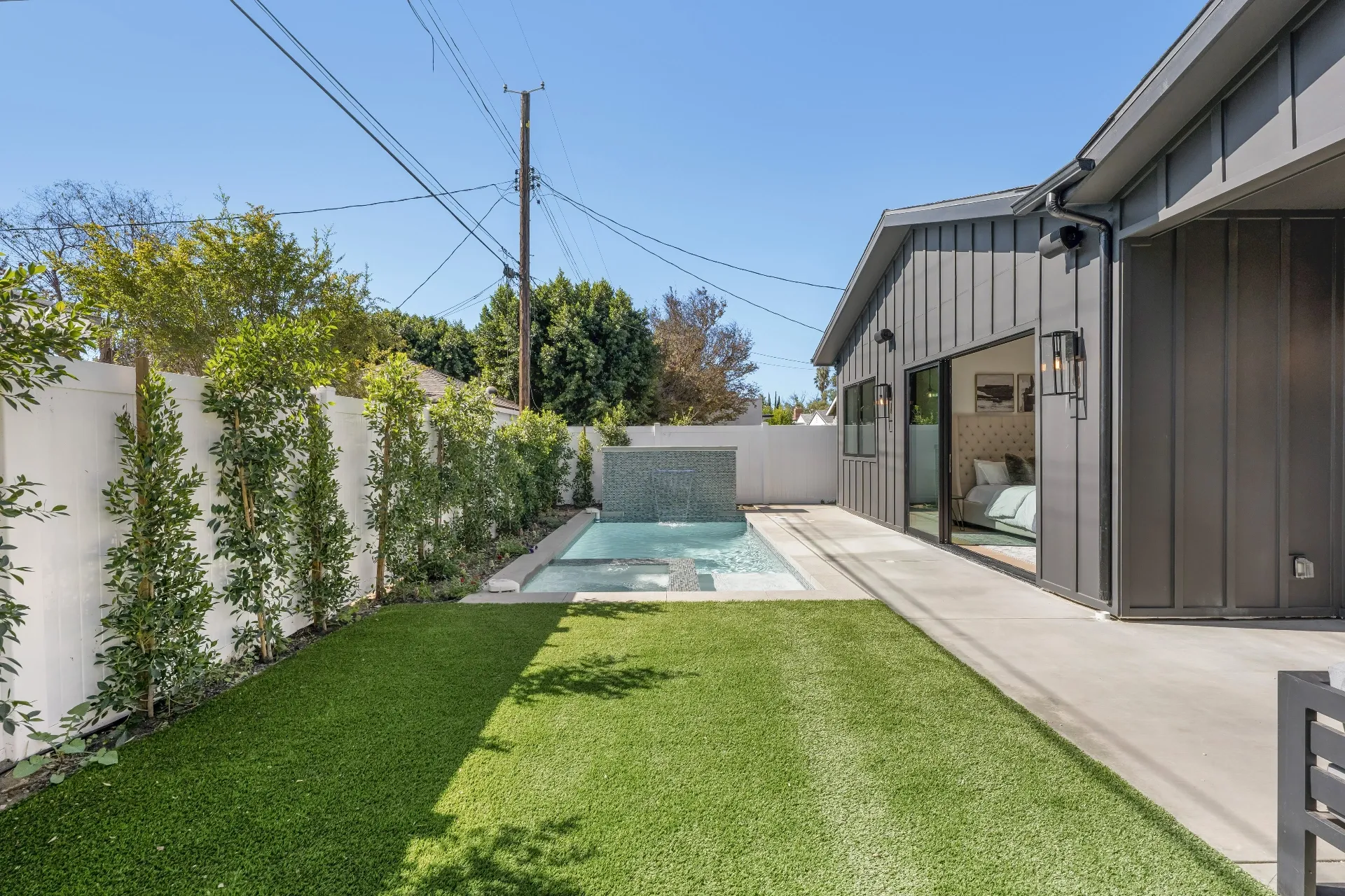 14602 Morrison St — Backyard: Complete backyard view showing pool, spa, landscaping, and seamless indoor-outdoor living