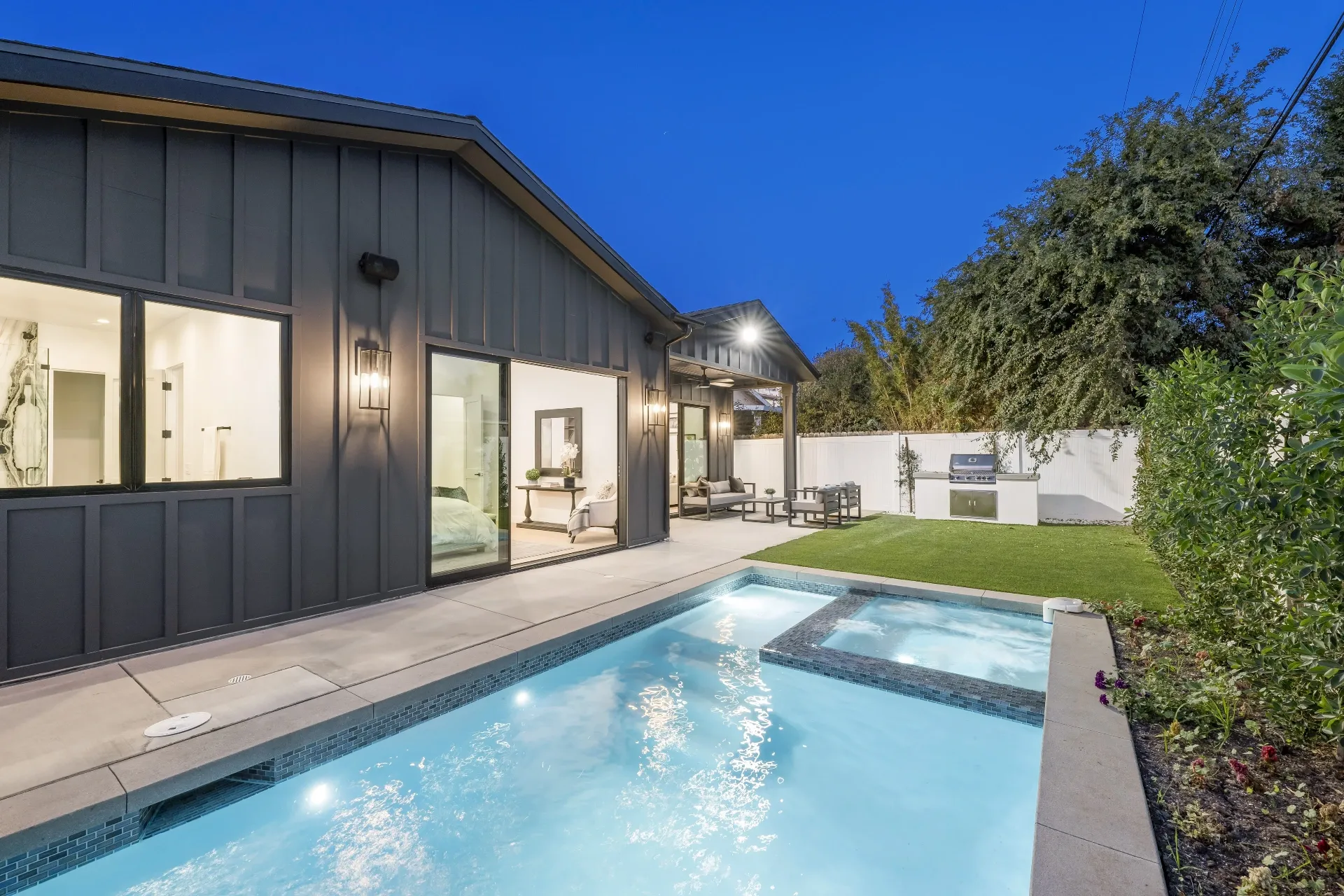 14602 Morrison St — Backyard: Evening pool lighting with LED water features and integrated spa overlooking outdoor BBQ area