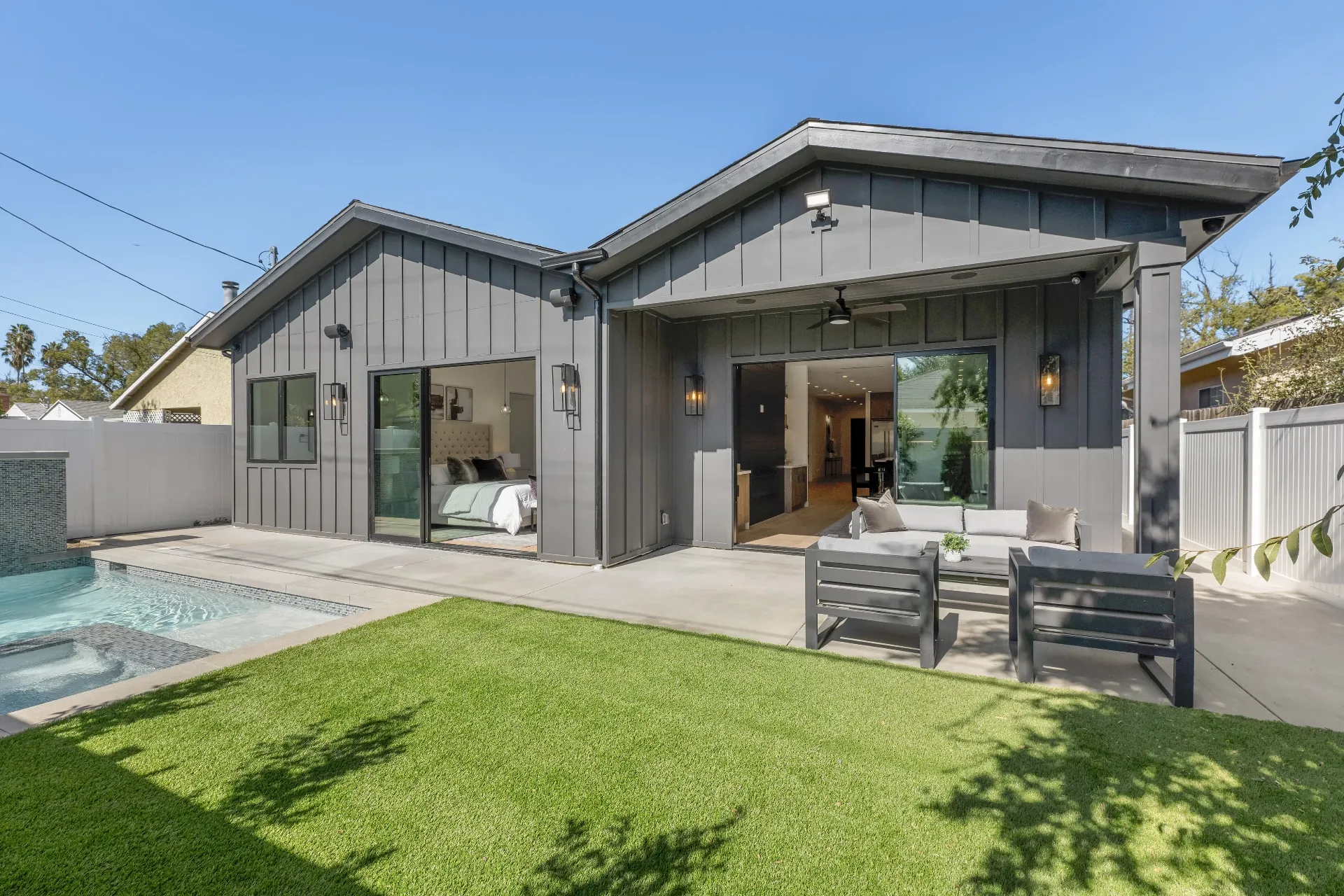 14602 Morrison St — Backyard: Modern farmhouse exterior showcasing board-and-batten siding, pool area, and covered outdoor living