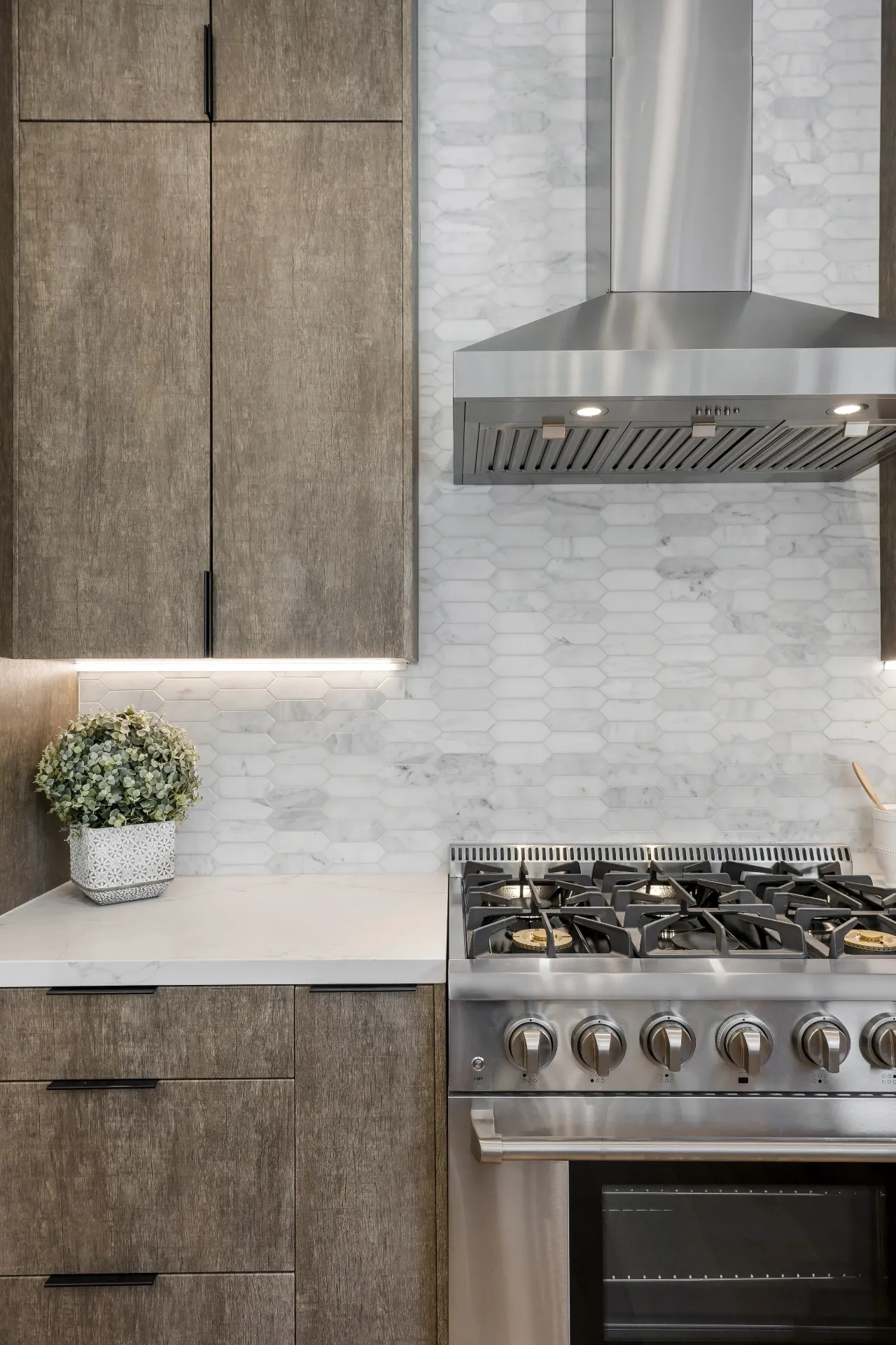 14602 Morrison St — Kitchen: Kitchen detail with wood-grain cabinets, marble hexagon backsplash, and stainless steel range