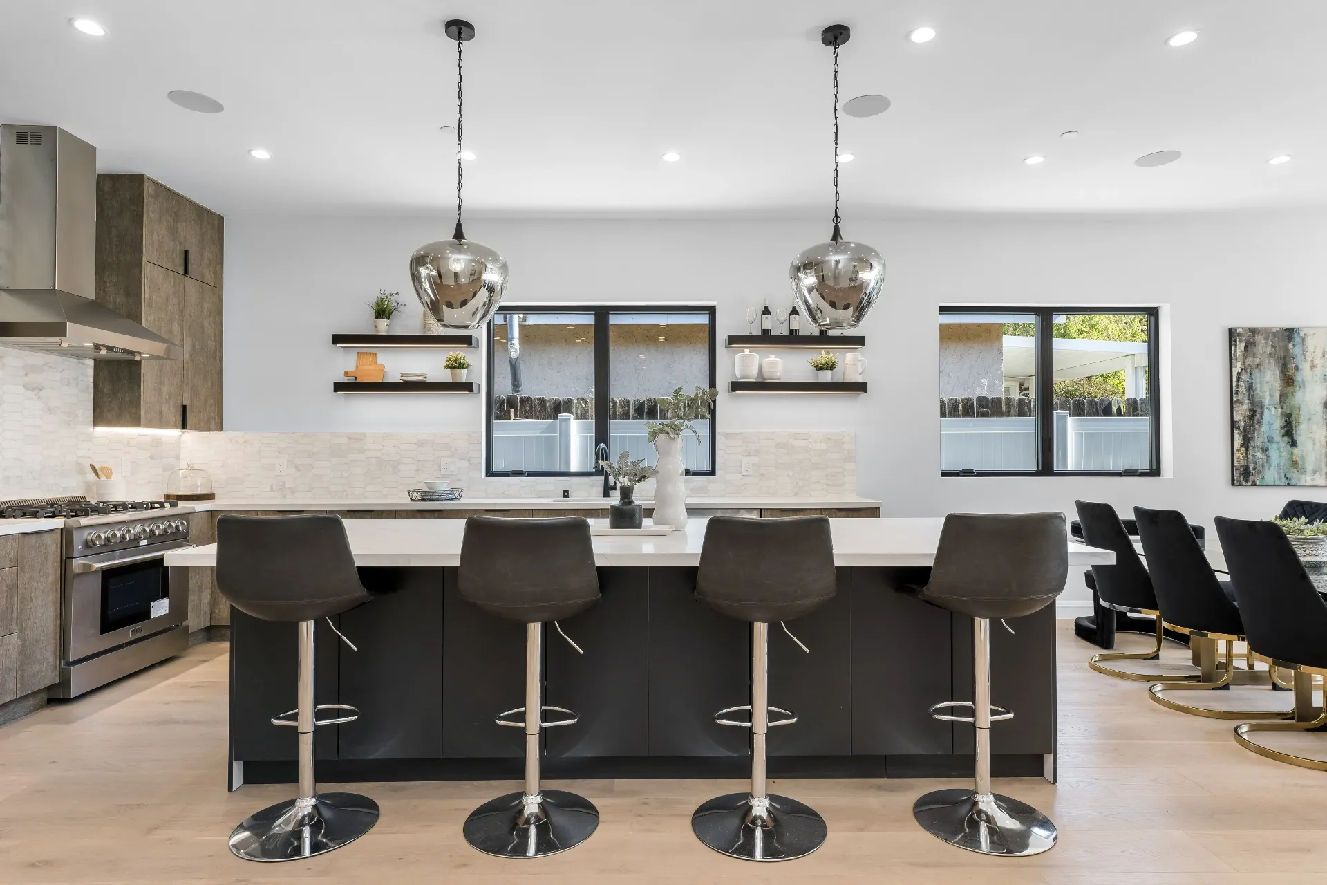 14602 Morrison St — Kitchen: Kitchen island with bar seating and floating shelves displaying ceramics