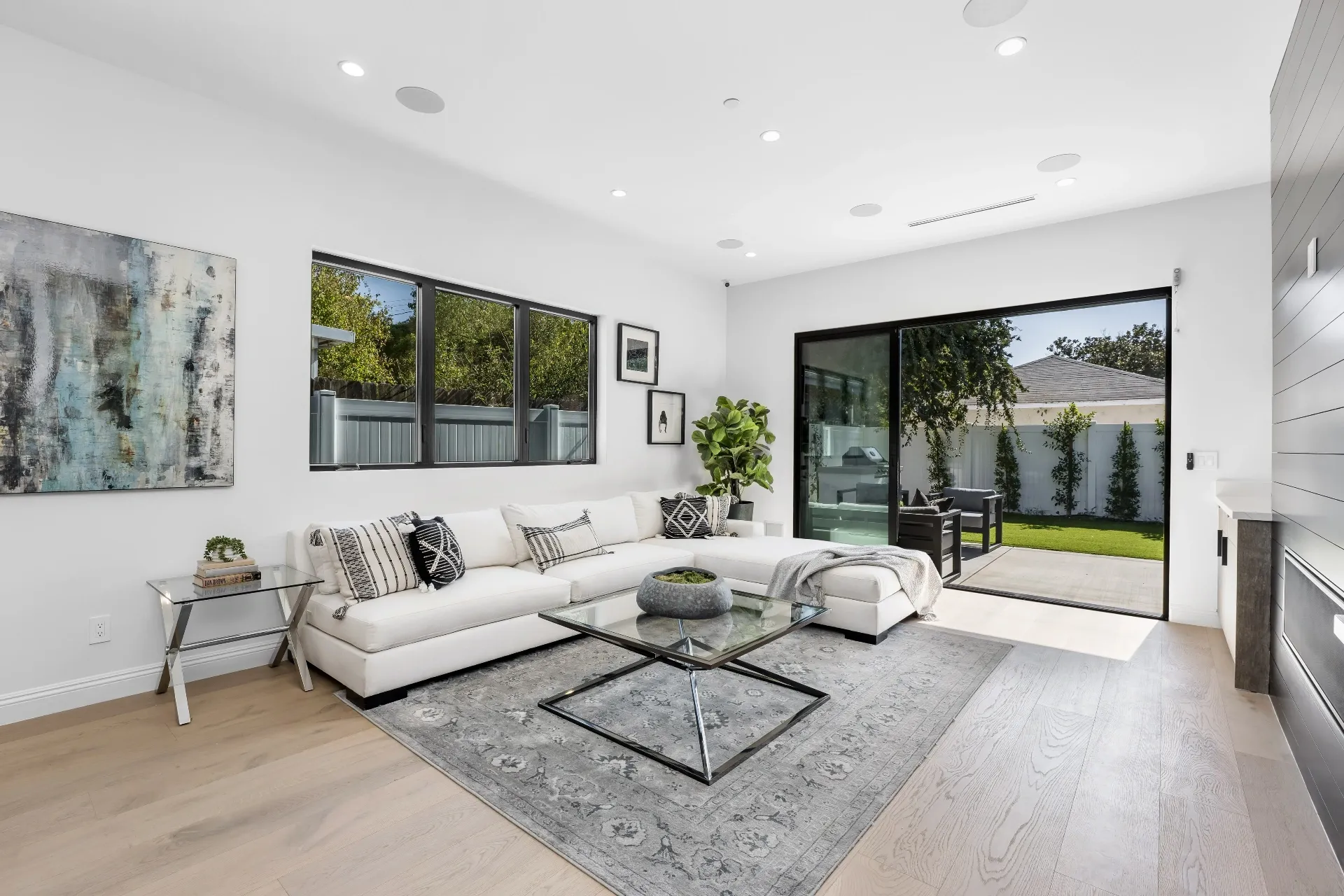 14602 Morrison St — Living Areas: Living room with white sectional, pool access, and contemporary artwork
