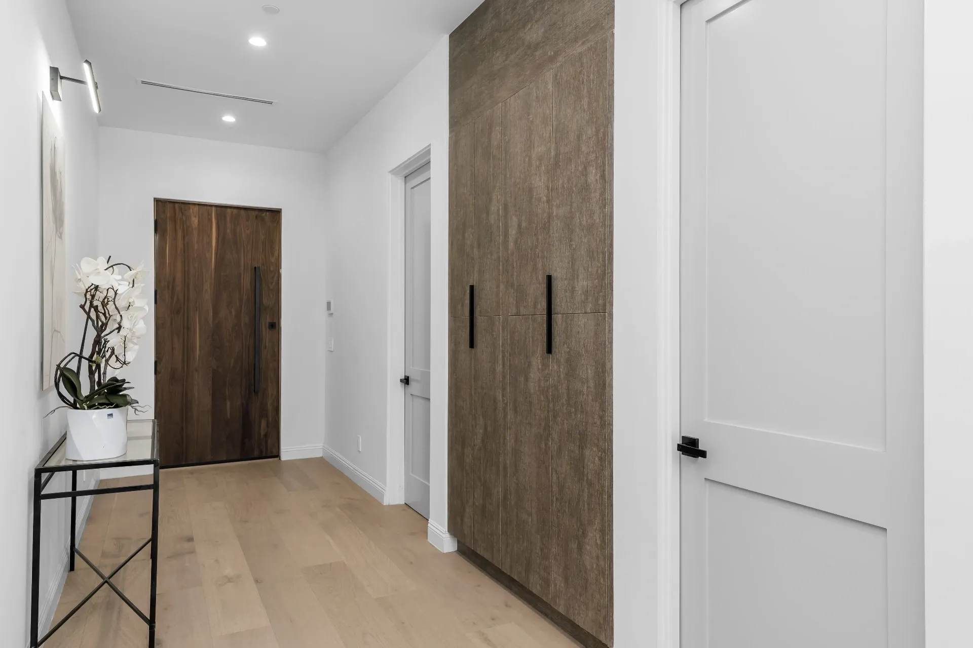 14602 Morrison St — Living Areas: Hallway with wood-grain storage cabinets and modern lighting fixtures