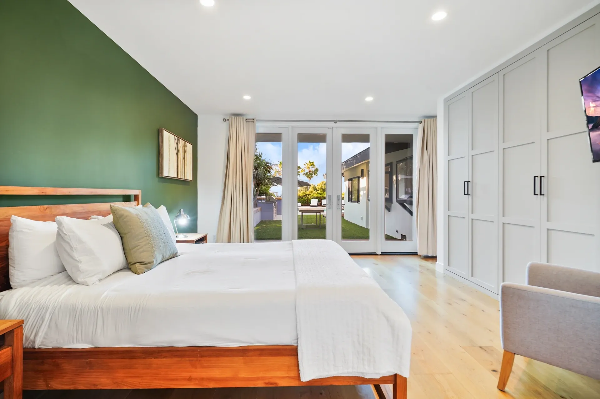 11308 Dona Teresa Dr — Bedrooms: Primary bedroom with green accent wall, French doors to outdoor space, and custom built-in storage