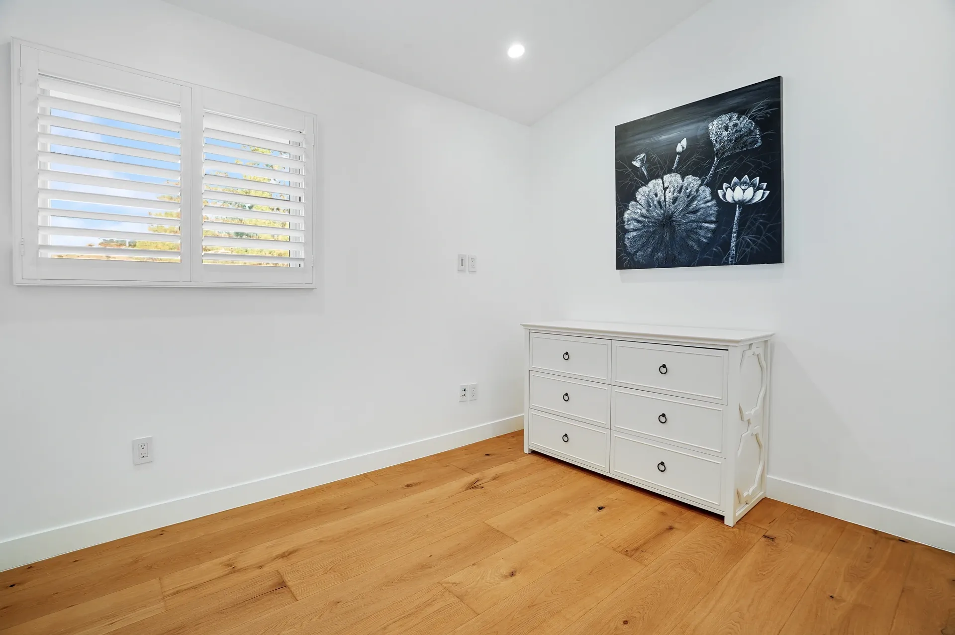 11308 Dona Teresa Dr — Bedrooms: Minimalist bedroom with white dresser, plantation shutters, and contemporary artwork