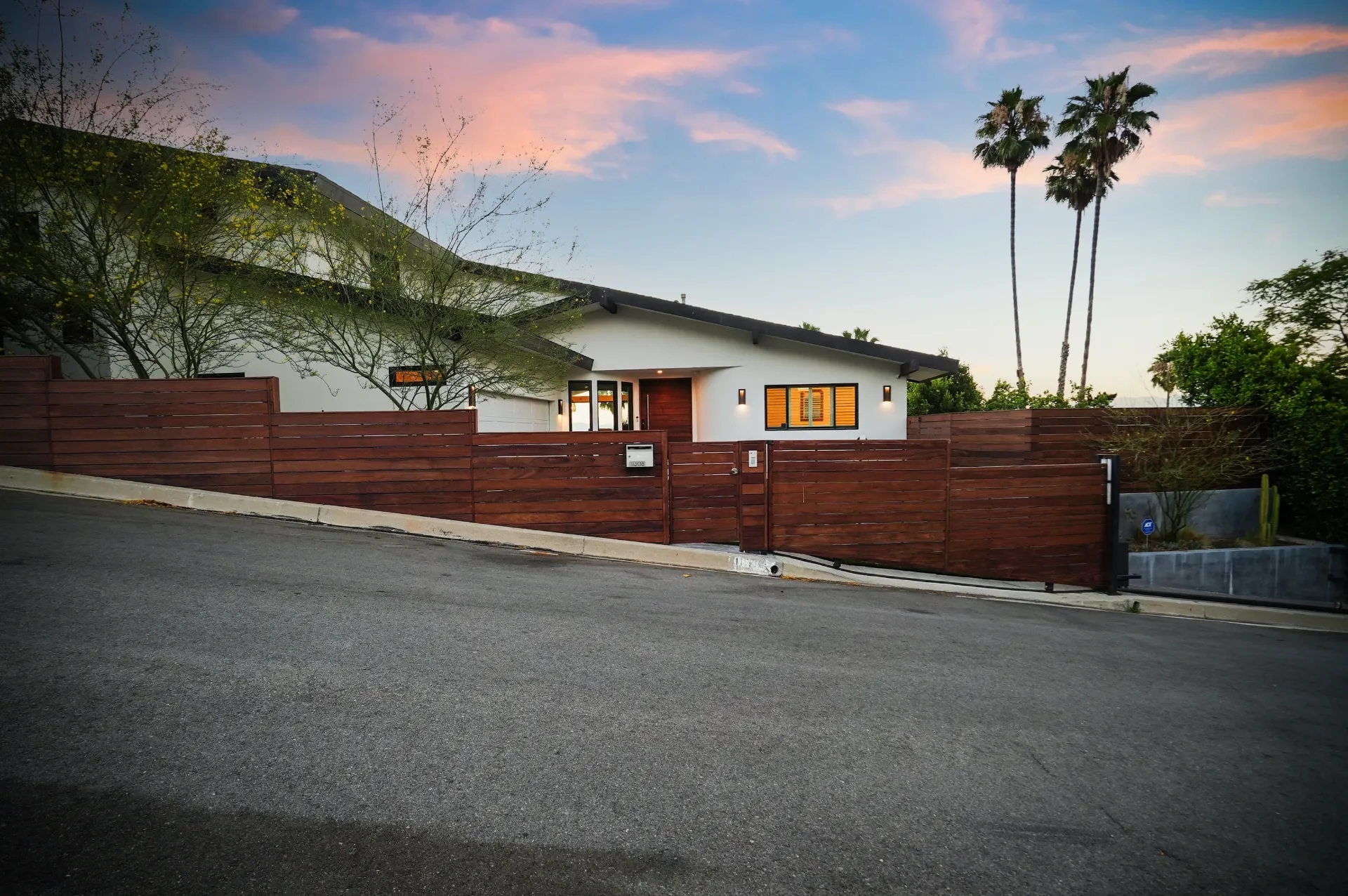 11308 Dona Teresa Dr — Exterior: Evening street perspective showcasing architectural lighting and contemporary wood fence design
