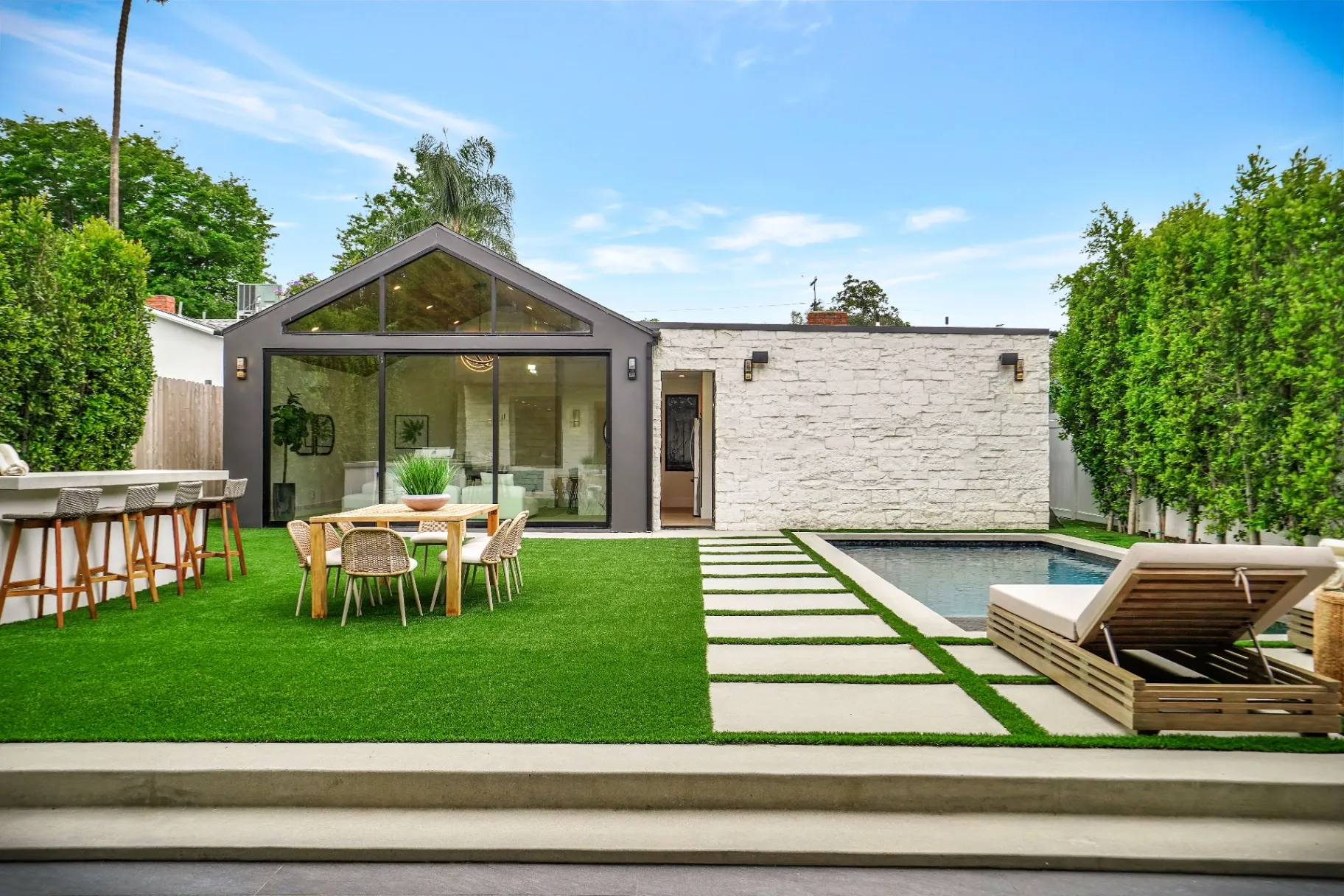 15602 Morrison St — Backyard: Pool area with outdoor dining space and contemporary glass-walled architecture