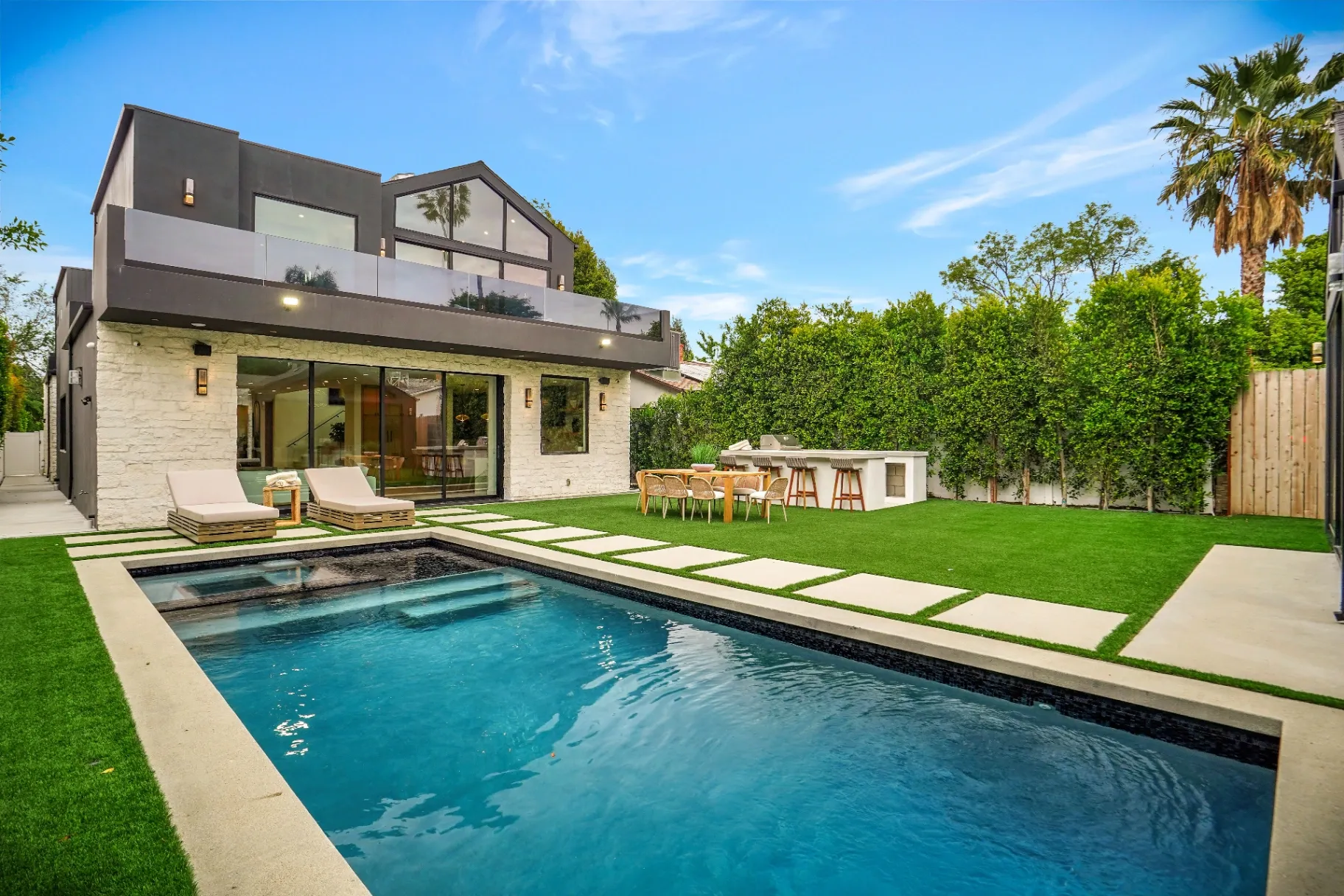 15602 Morrison St — Backyard: Modern two-story home with backyard pool, outdoor dining, and upper deck