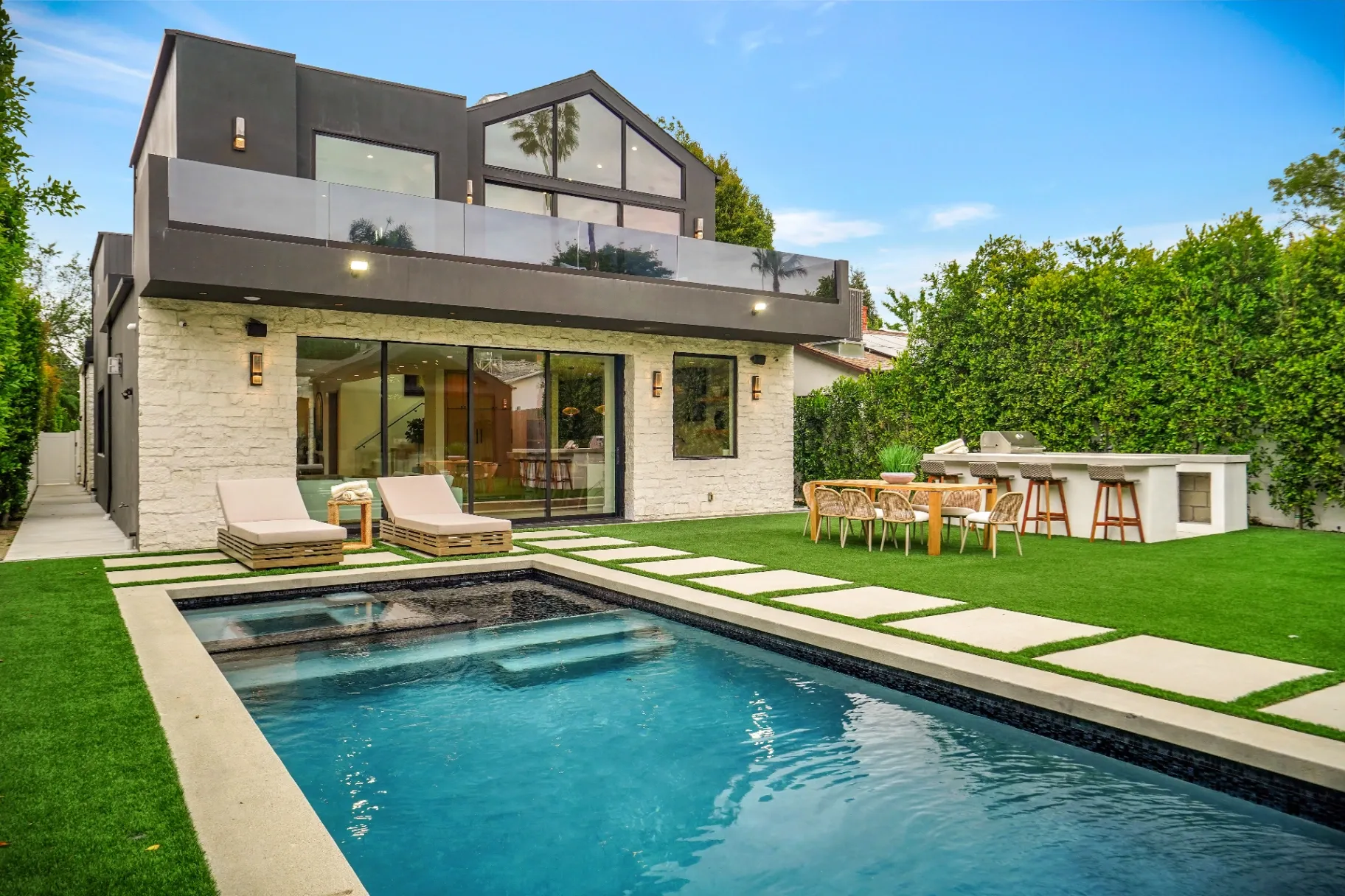 15602 Morrison St — Backyard: Luxury backyard with pool, spa, artificial grass, and integrated outdoor kitchen