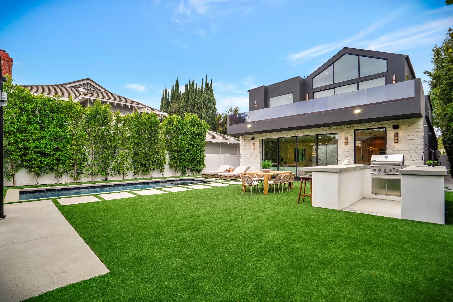 15602 Morrison St — Backyard: Backyard oasis with rectangular pool, outdoor kitchen, and beautiful landscaping