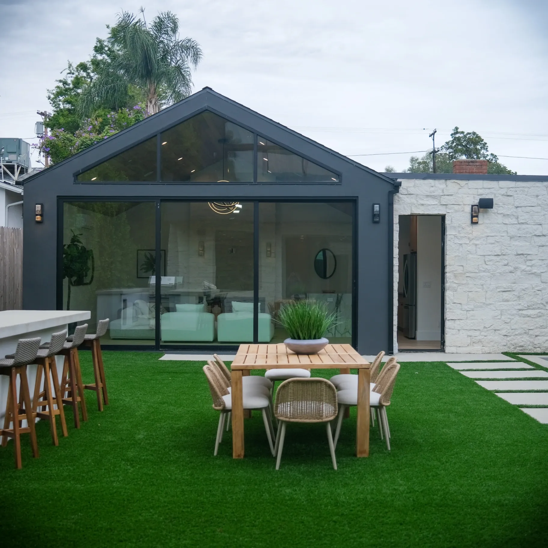 15602 Morrison St — Backyard: 15602 Morrison St — Contemporary backyard with artificial turf, outdoor dining area, and glass-walled architecture