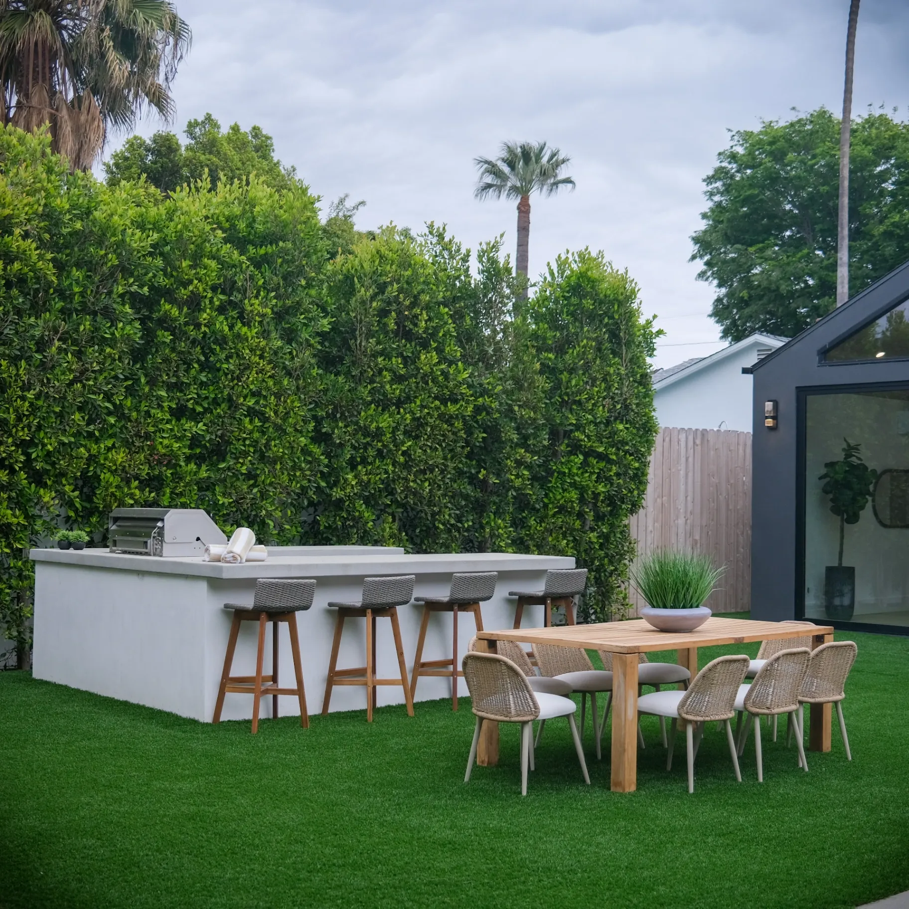 15602 Morrison St — Backyard: 15602 Morrison St — Outdoor kitchen and bar area with artificial grass and contemporary outdoor dining furniture