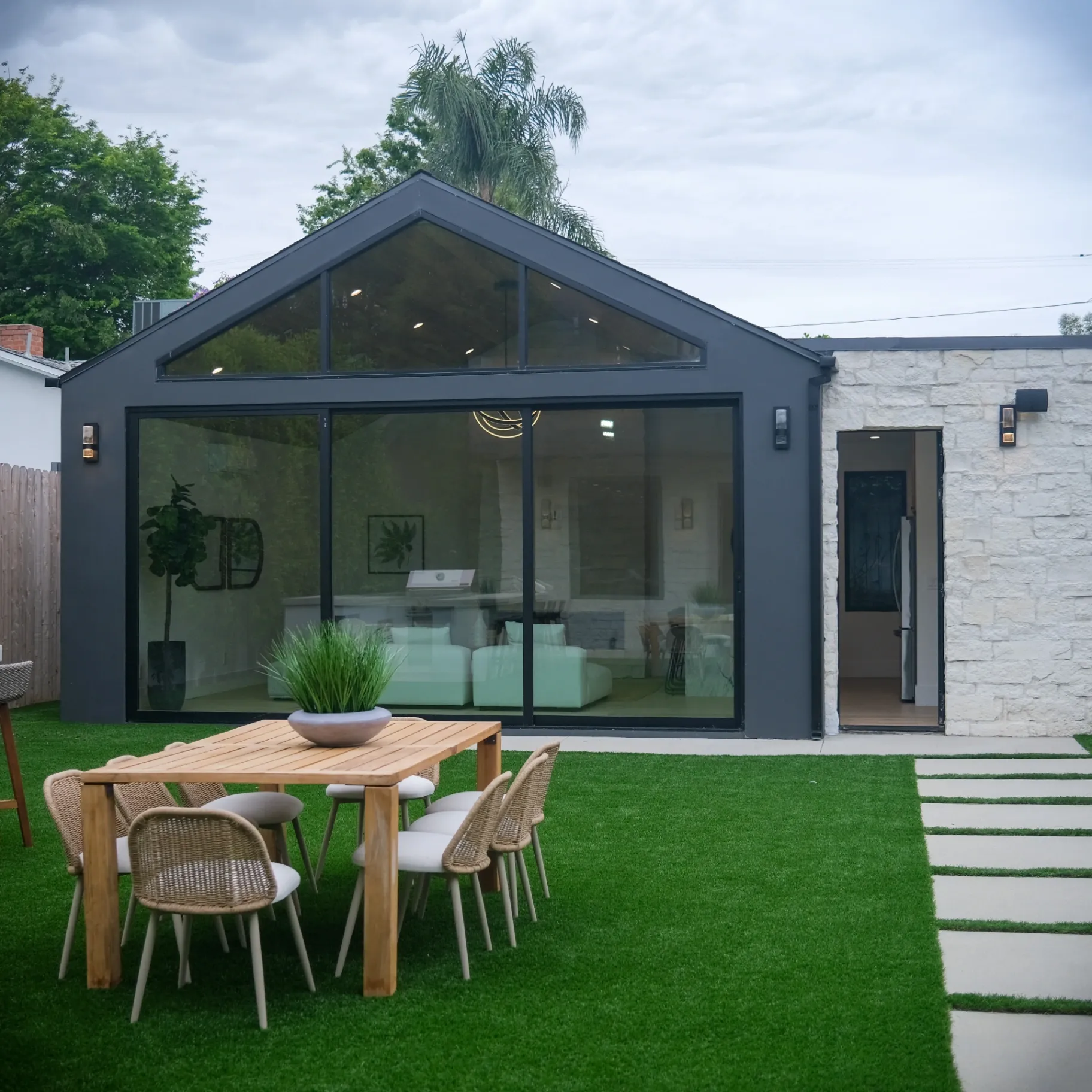 15602 Morrison St — Backyard: 15602 Morrison St — Modern backyard with outdoor dining table, artificial turf, and seamless indoor-outdoor flow