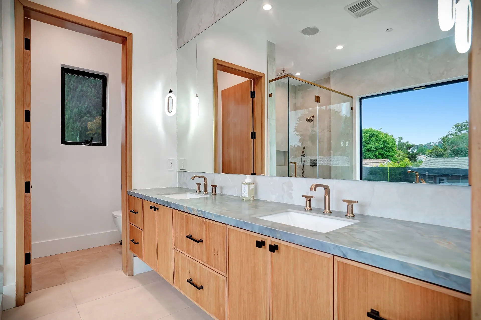 15602 Morrison St — Bathrooms: 15602 Morrison St — Primary bathroom featuring double vanity with wood cabinetry, marble countertops, and brass fixtures with city views