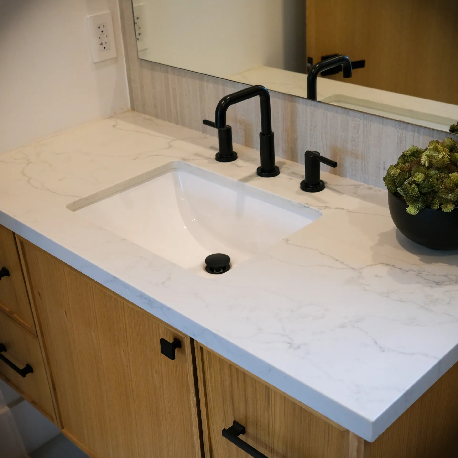 15602 Morrison St — Bathrooms: 15602 Morrison St — Bathroom vanity with wood cabinetry, white marble countertop, black fixtures, and modern mirror