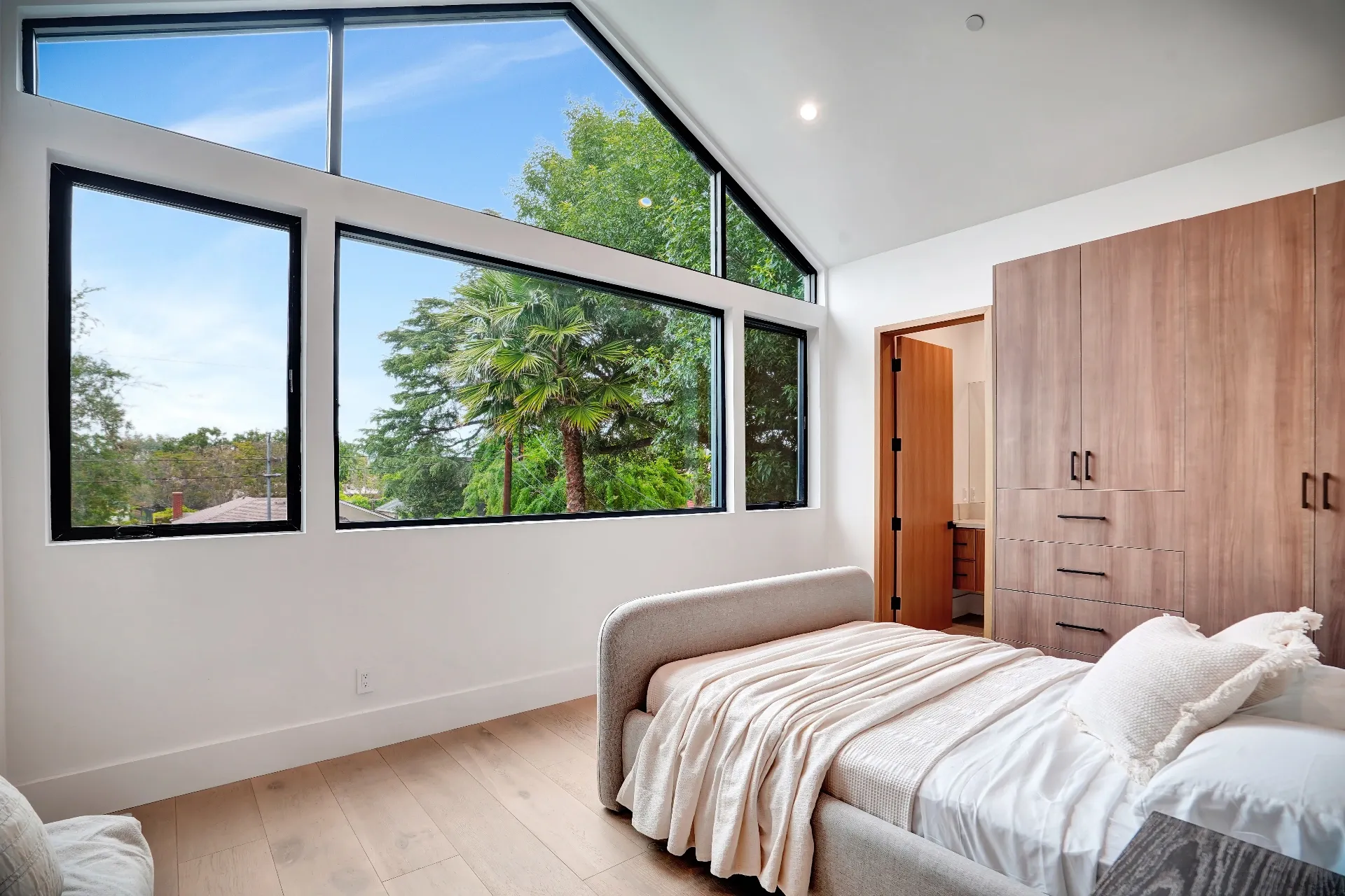 15602 Morrison St — Bedrooms: 15602 Morrison St — Bedroom with large windows, white upholstered platform bed, and wood cabinetry