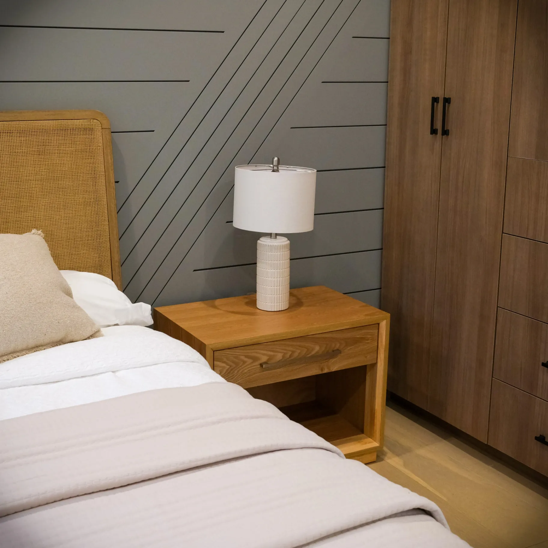 15602 Morrison St — Bedrooms: 15602 Morrison St — Bedroom detail showing diagonal wood slat wall, rattan bed frame, and floating wood nightstand with modern lamp