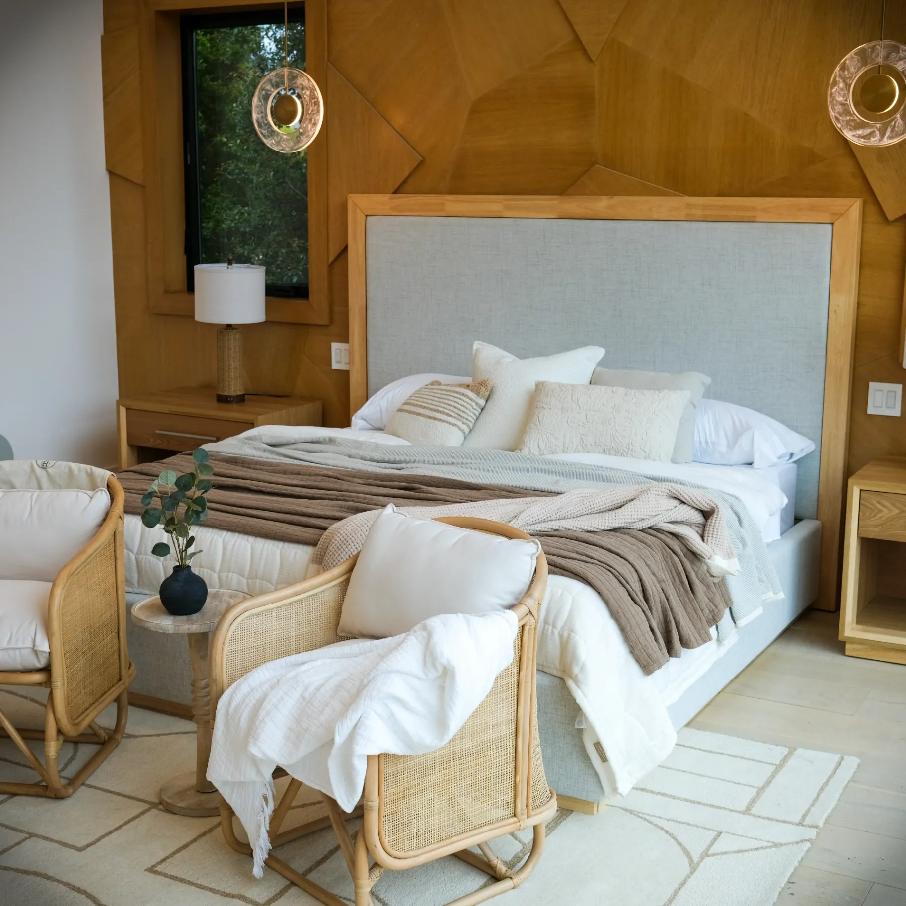 15602 Morrison St — Bedrooms: 15602 Morrison St — Primary bedroom with geometric wood feature wall, neutral bedding, rattan seating area, and modern lighting