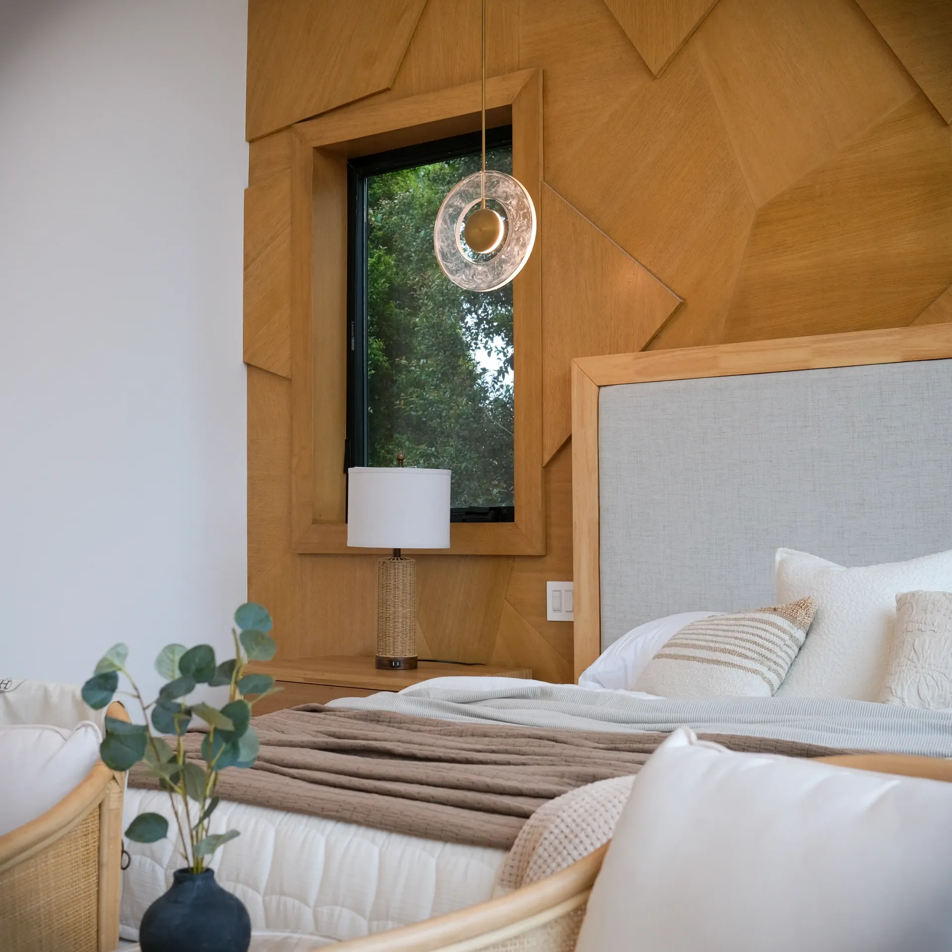 15602 Morrison St — Bedrooms: 15602 Morrison St — Bedroom detail featuring geometric wood wall design, neutral bedding, and contemporary pendant lighting