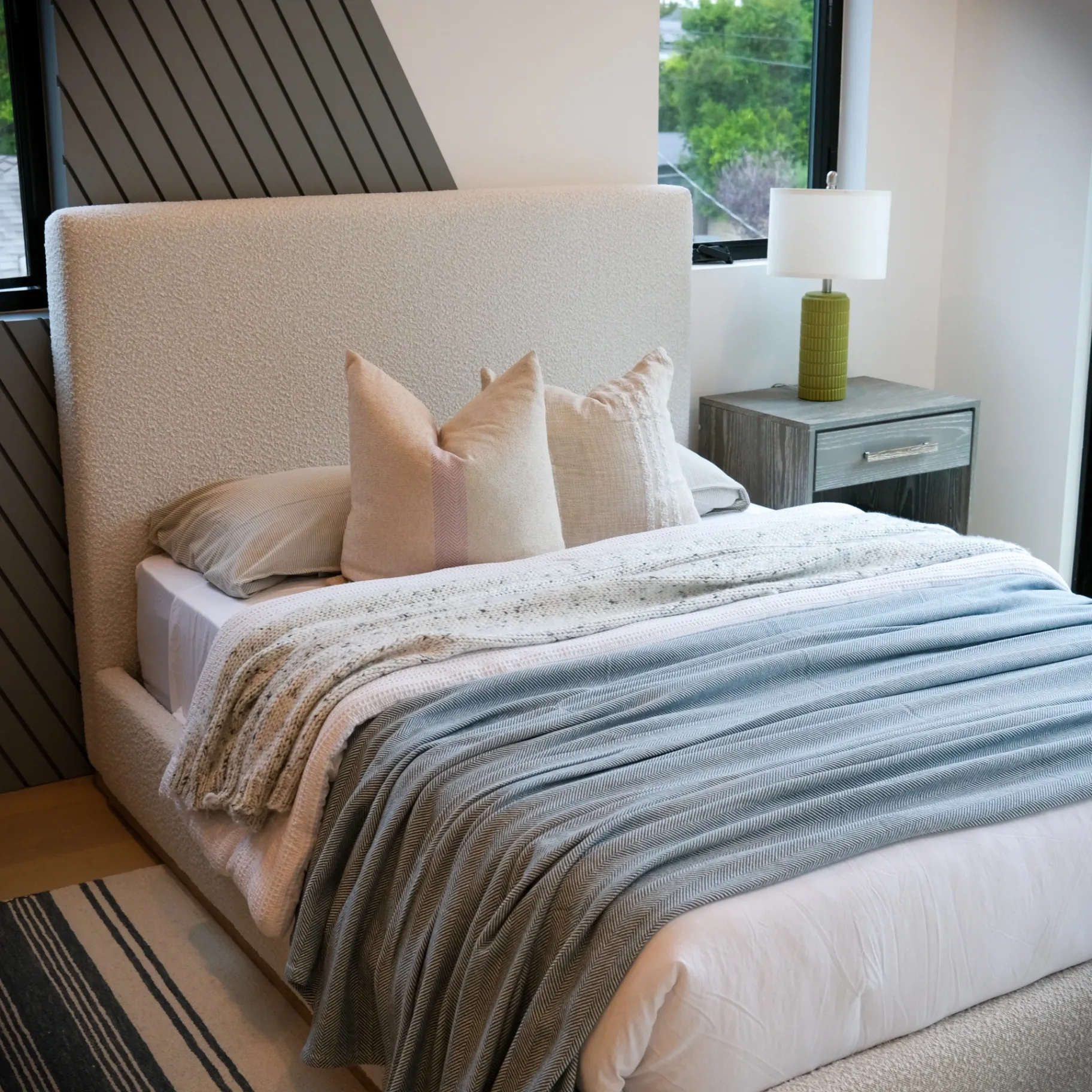 15602 Morrison St — Bedrooms: 15602 Morrison St — Contemporary bedroom featuring diagonal wood slat wall, neutral bedding, and striped area rug