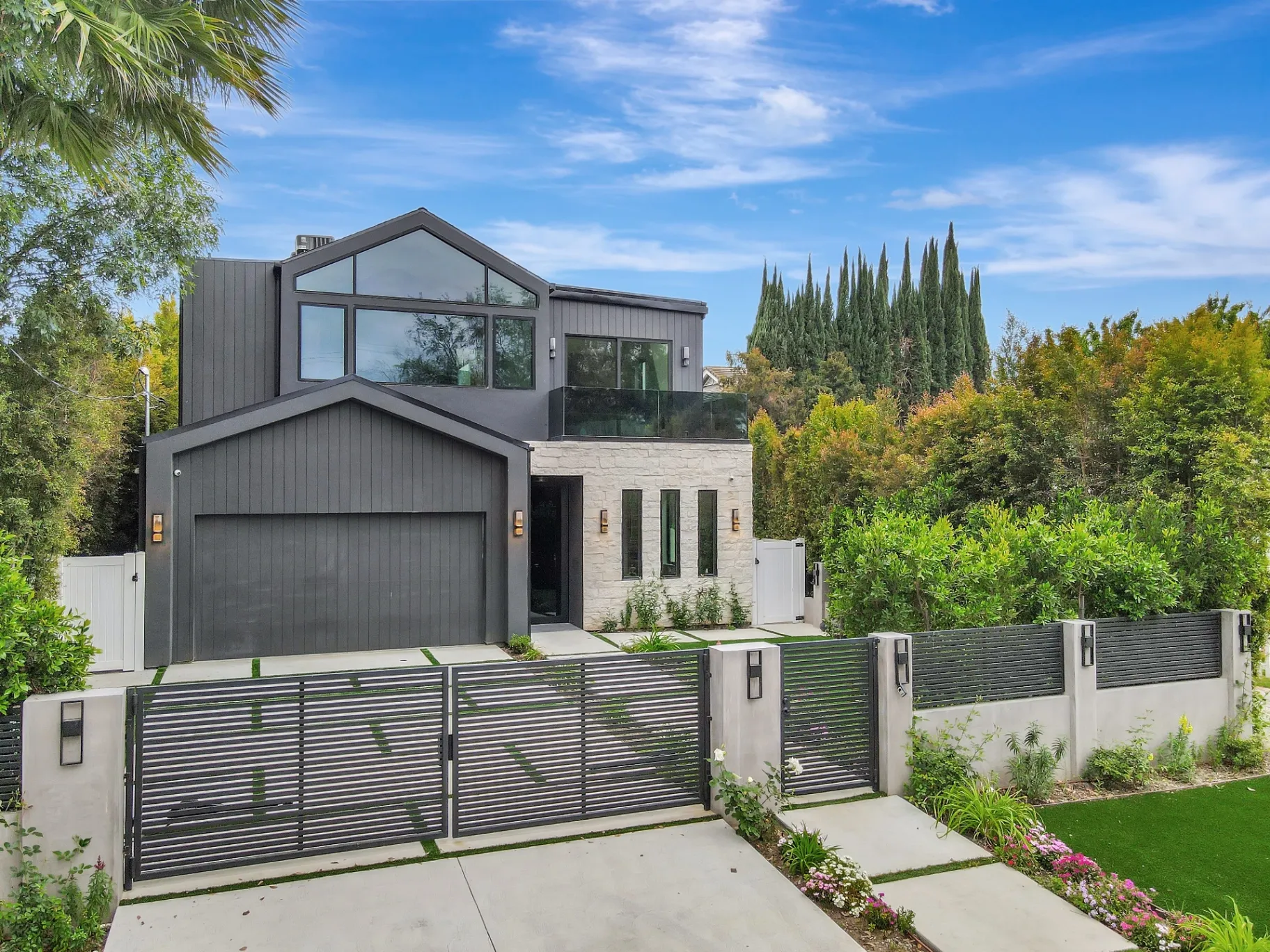 15602 Morrison St — Exterior: 15602 Morrison St — Modern contemporary home exterior with horizontal-slat gate, stone accents, and mature landscaping