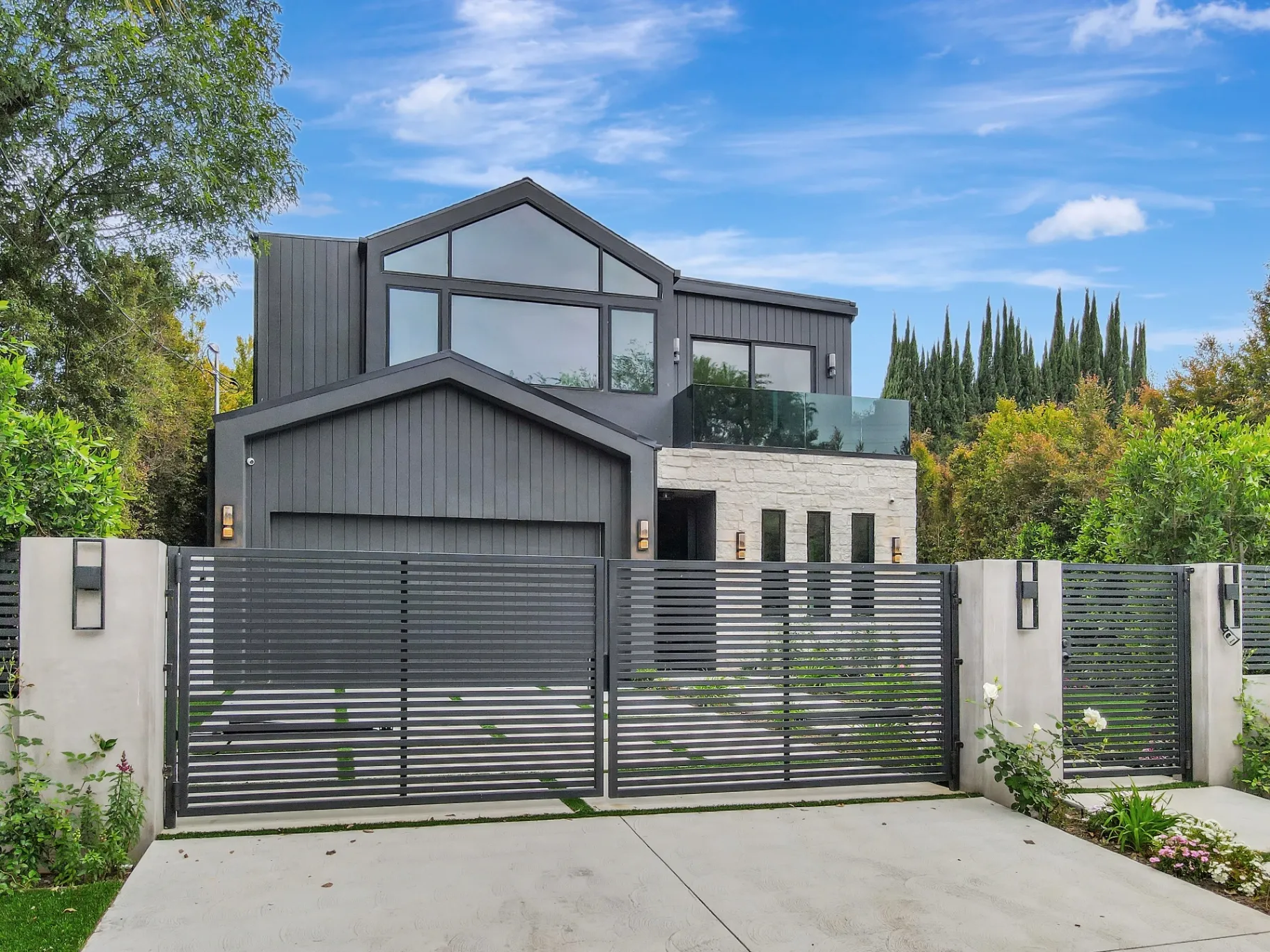 15602 Morrison St — Exterior: 15602 Morrison St — Contemporary home facade with horizontal-slat gates, landscaped front yard, and modern outdoor lighting