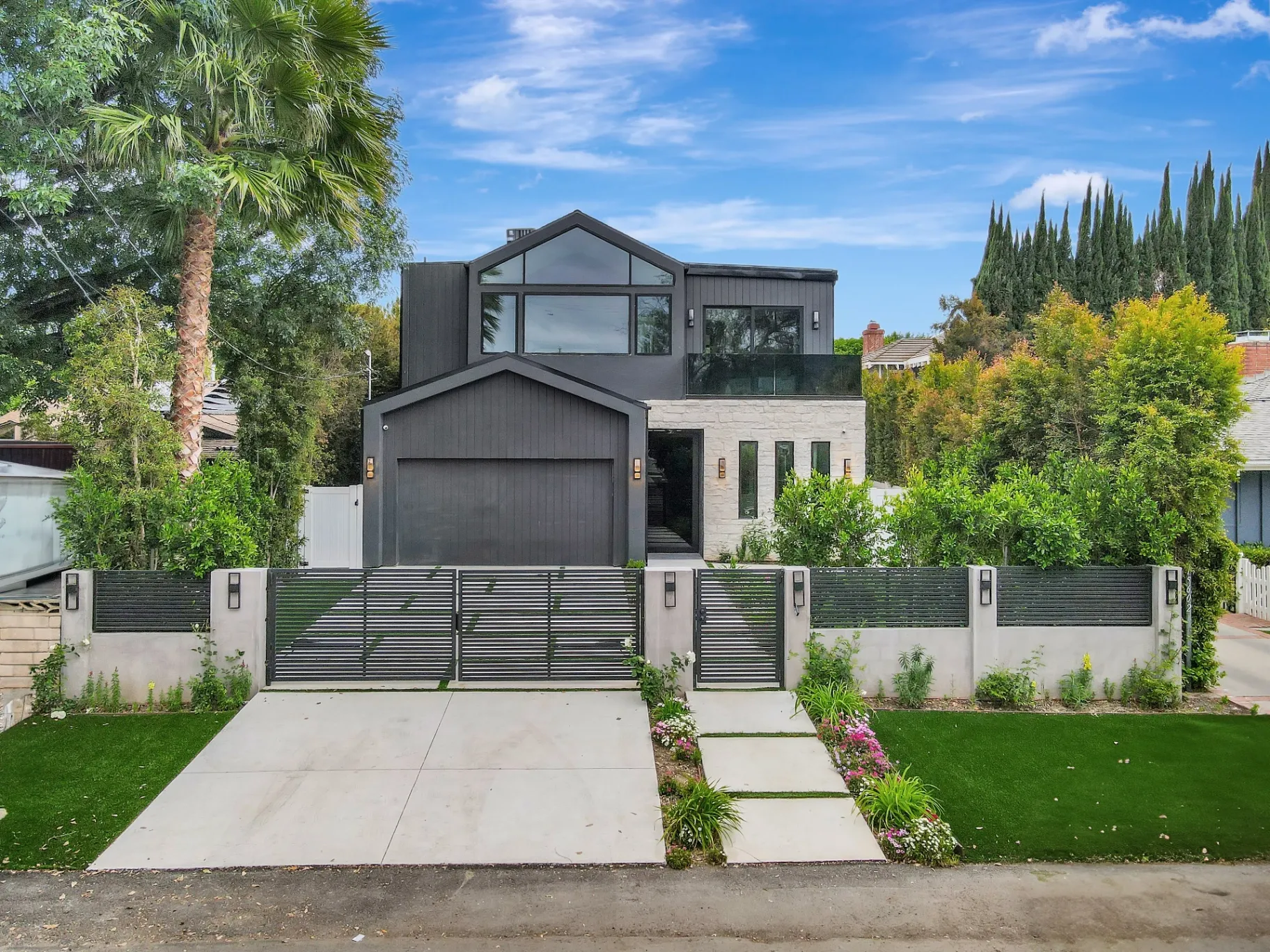 15602 Morrison St — Exterior: 15602 Morrison St — Modern exterior with dark vertical siding, white stone accents, and professionally landscaped front entrance