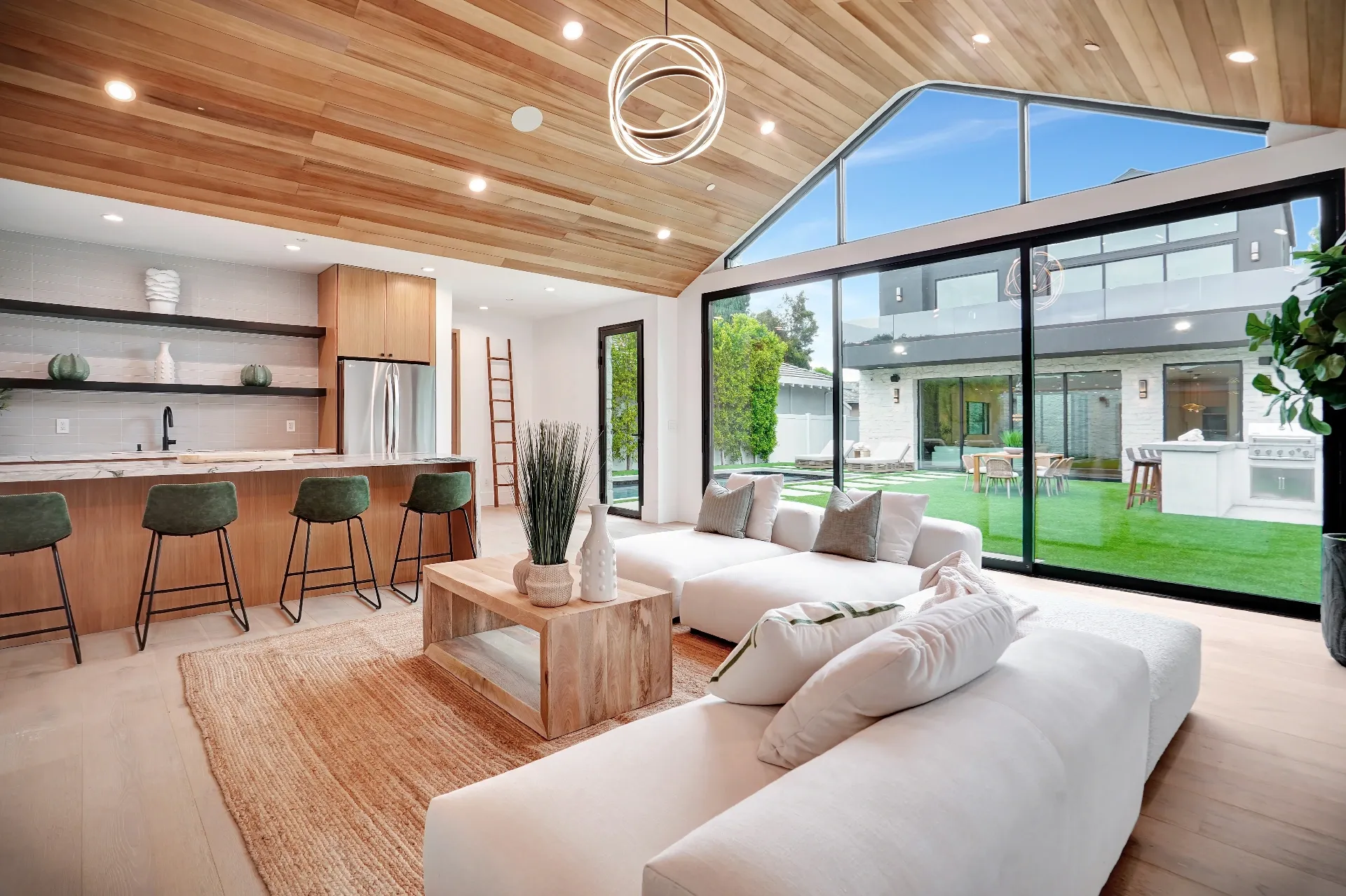 15602 Morrison St — Guest House: 15602 Morrison St — Guest house living room with floor-to-ceiling windows, white sectional, and views to outdoor pool area