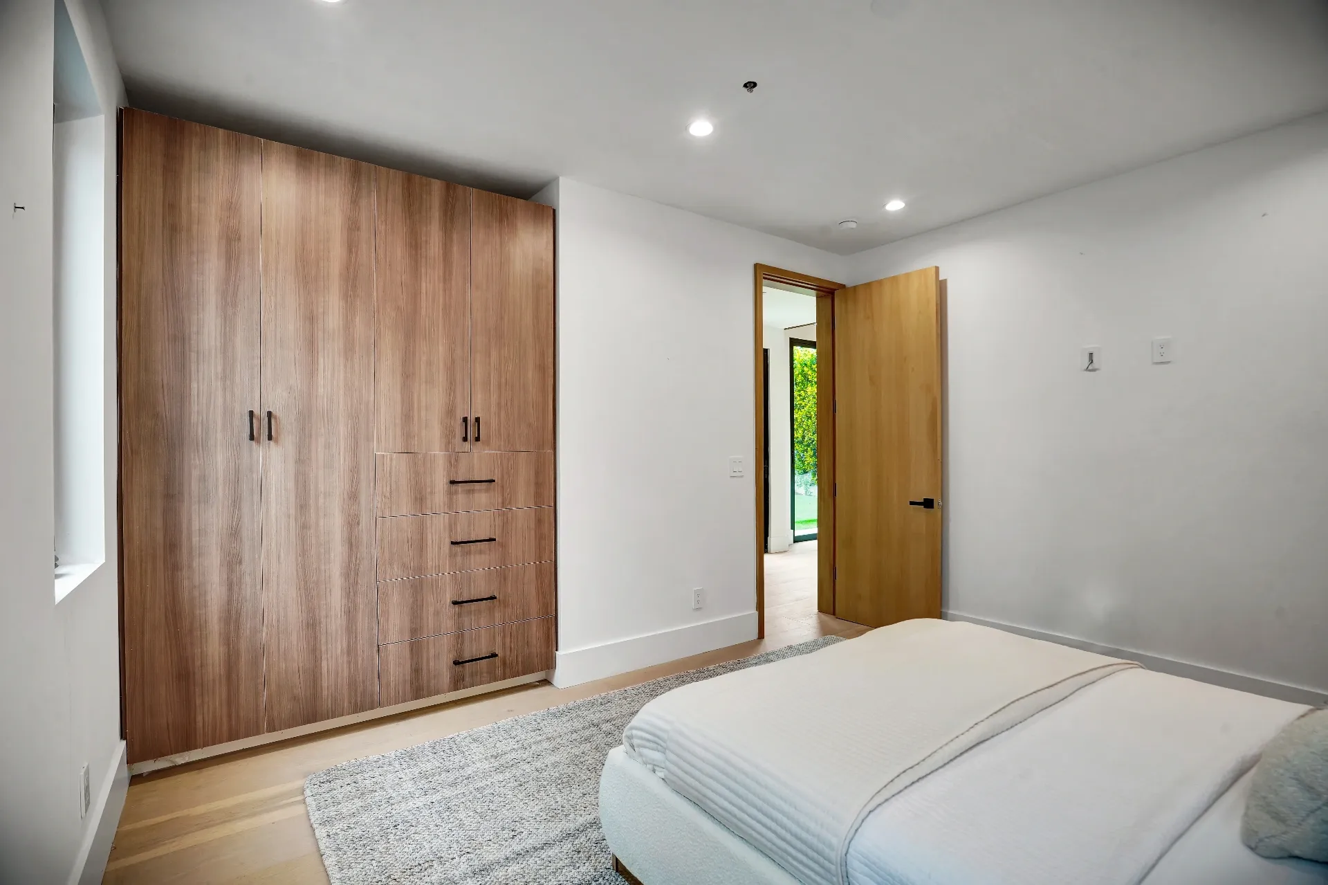 15602 Morrison St — Guest House: 15602 Morrison St — Guest house bedroom featuring built-in wood wardrobes, contemporary bed, and clean modern architecture
