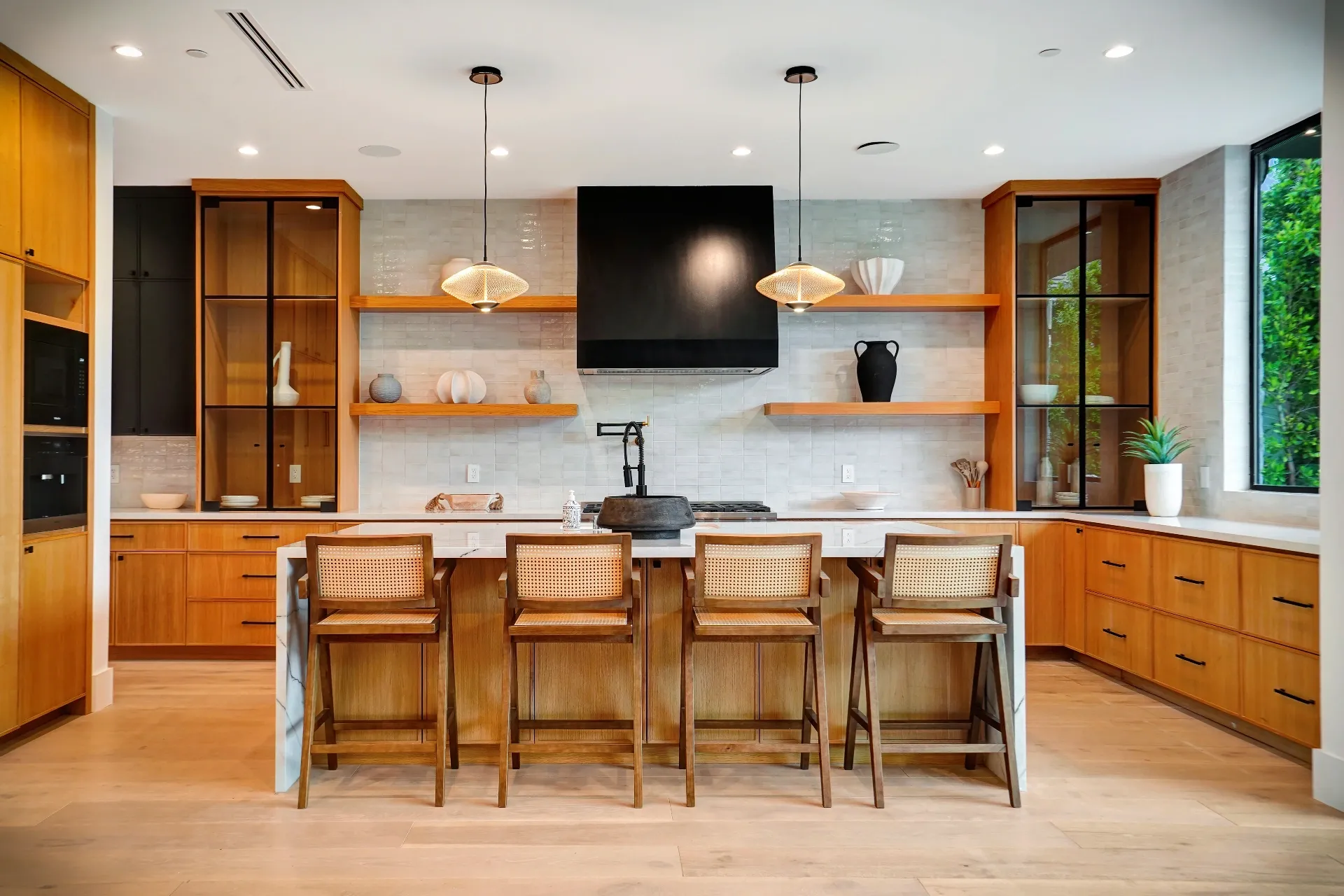 15602 Morrison St — Kitchen: 15602 Morrison St — Gourmet kitchen with wood cabinetry, marble waterfall island, cane bar stools, and pendant lighting