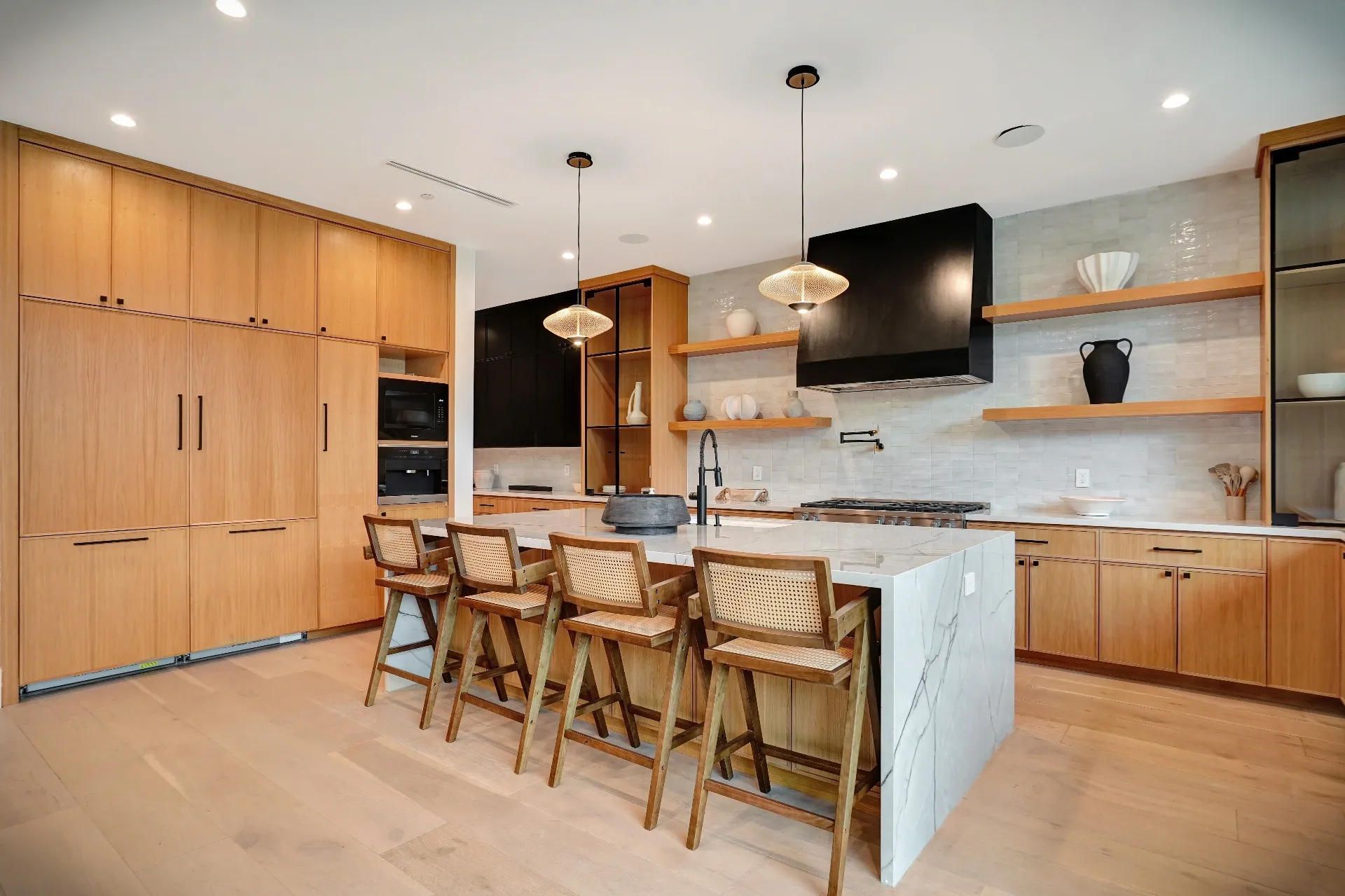 15602 Morrison St — Kitchen: 15602 Morrison St — Kitchen with wood cabinetry, marble countertops, cane bar stools, and integrated appliances