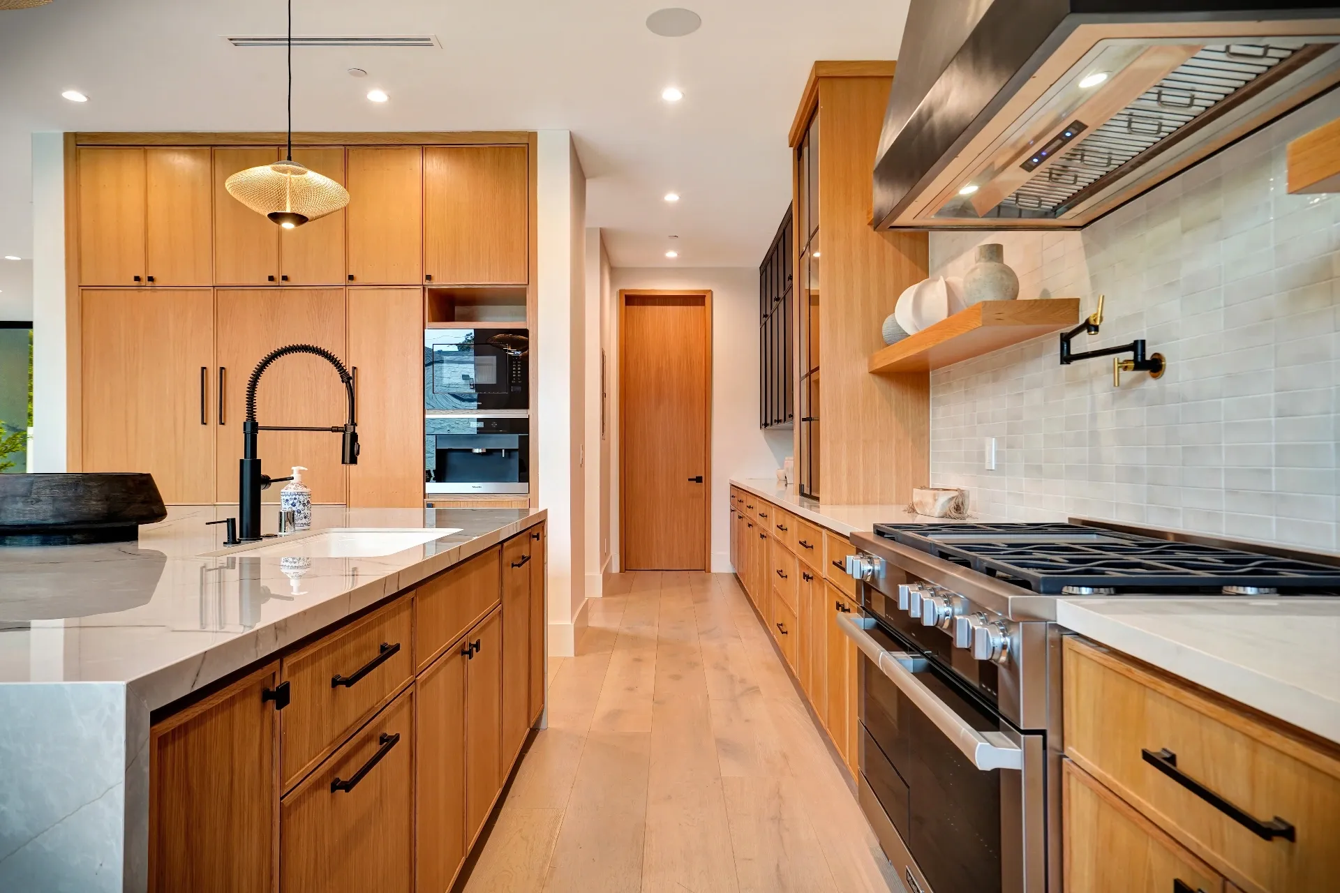 15602 Morrison St — Kitchen: 15602 Morrison St — Galley kitchen with wood cabinets, marble countertops, professional range, and pendant lighting