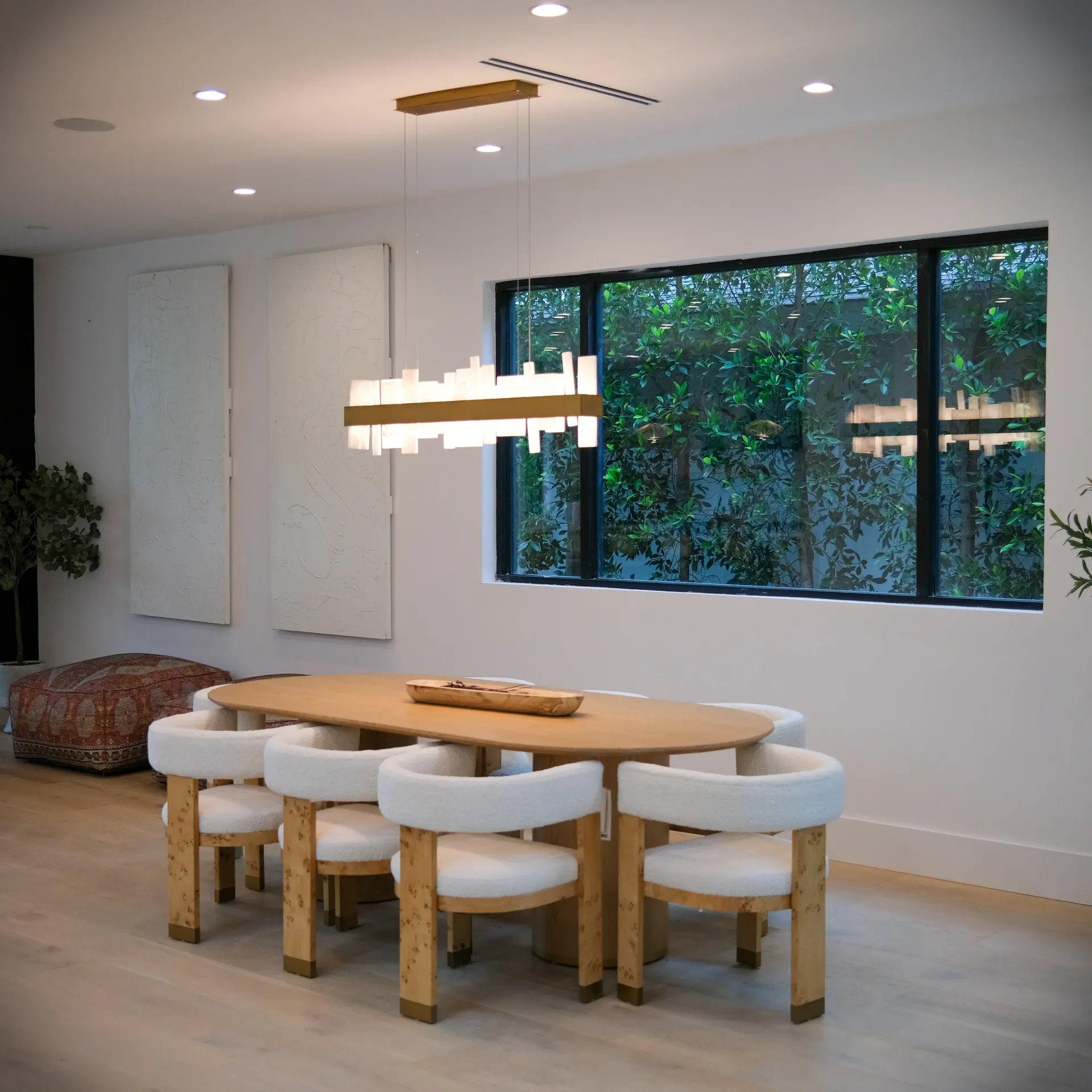 15602 Morrison St — Kitchen: 15602 Morrison St — Modern dining area with oval wood table, white upholstered chairs, sculptural chandelier, and garden views