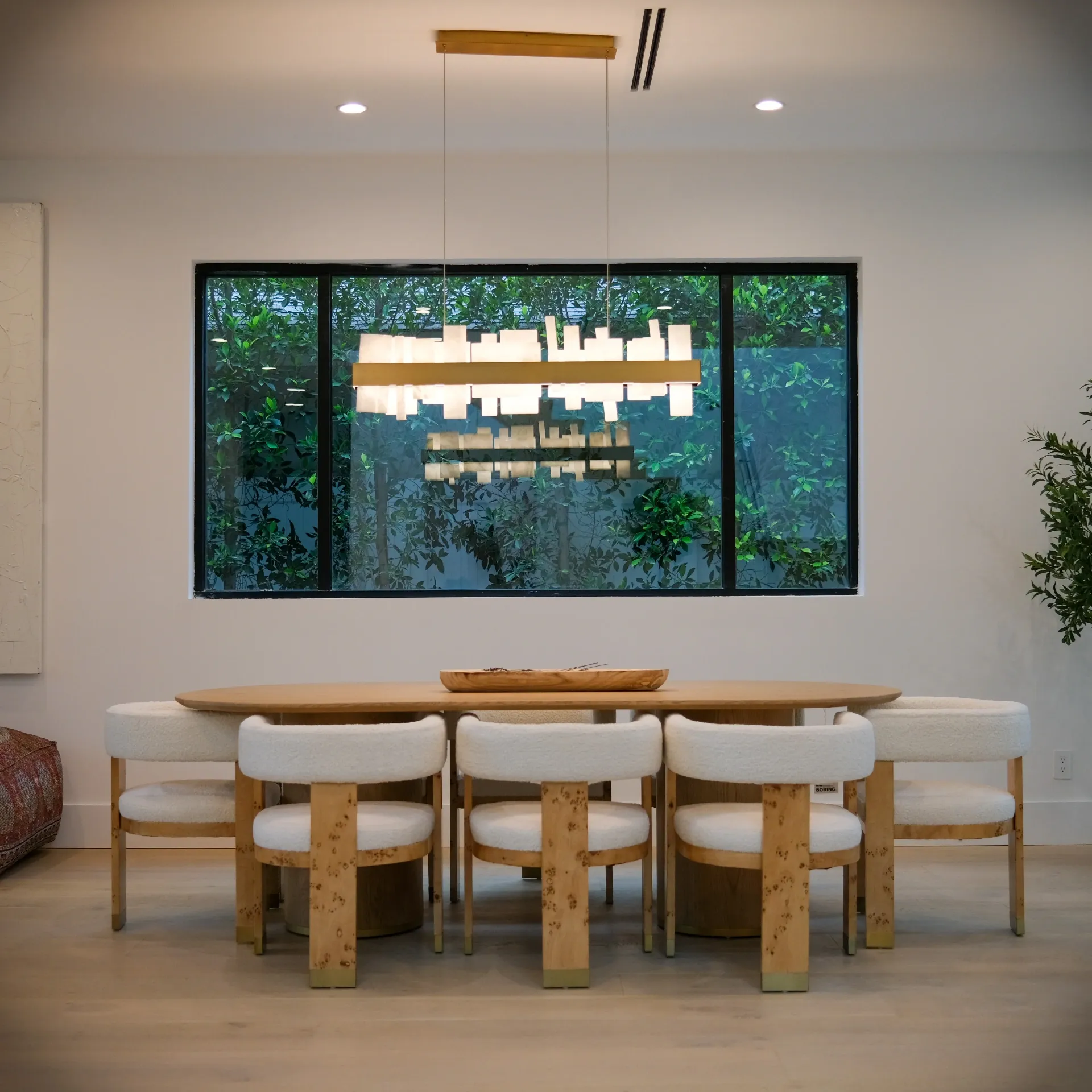 15602 Morrison St — Kitchen: 15602 Morrison St — Elegant dining space with wood table, upholstered seating, modern chandelier, and outdoor courtyard access
