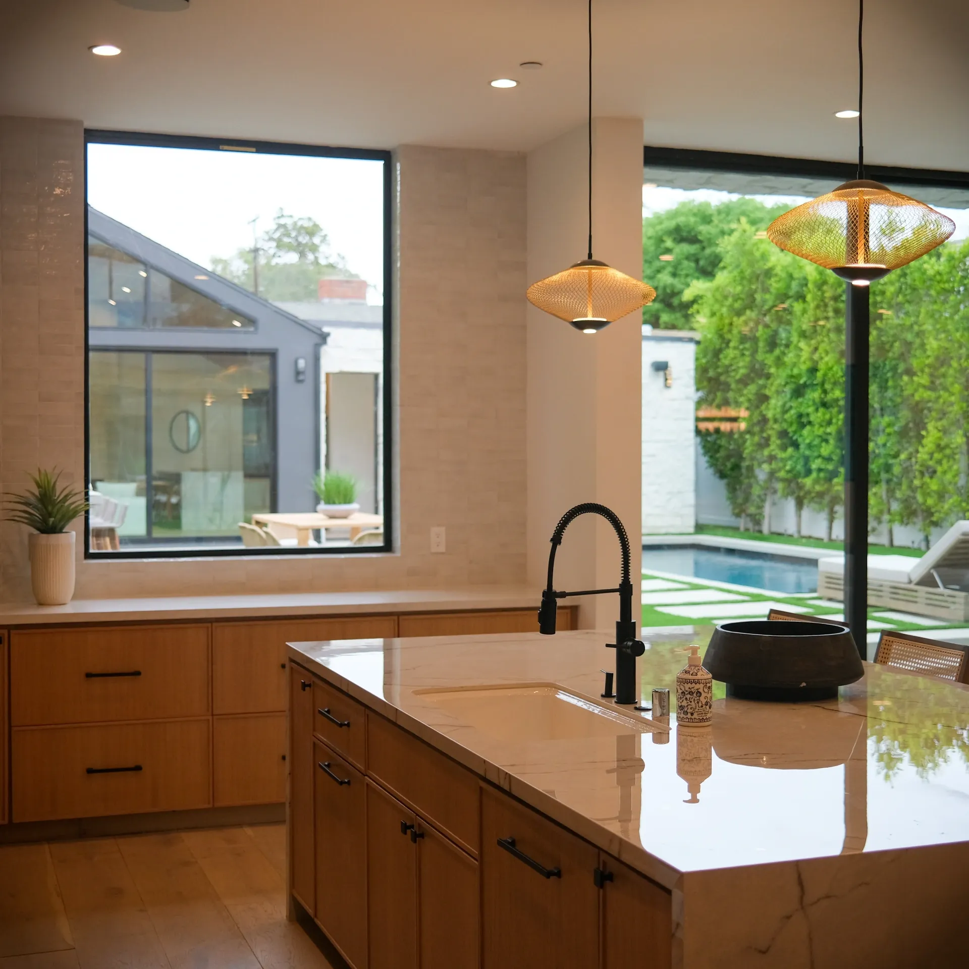15602 Morrison St — Kitchen: 15602 Morrison St — Gourmet kitchen with marble island, wood and black cabinetry, pendant lights, and pool views