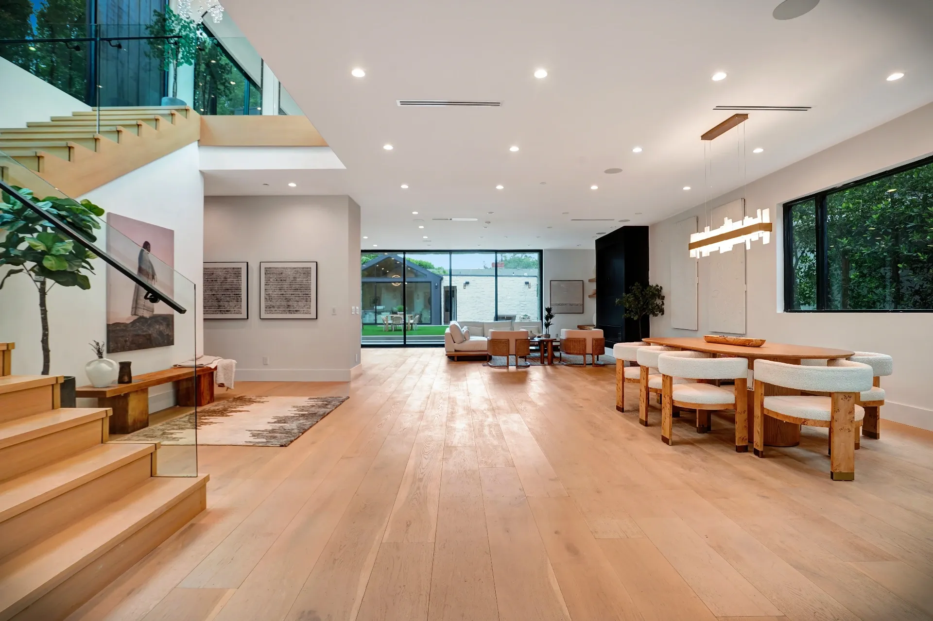 15602 Morrison St — Living Areas: 15602 Morrison St — Great room with floating staircase, modern dining table, and floor-to-ceiling windows overlooking pool