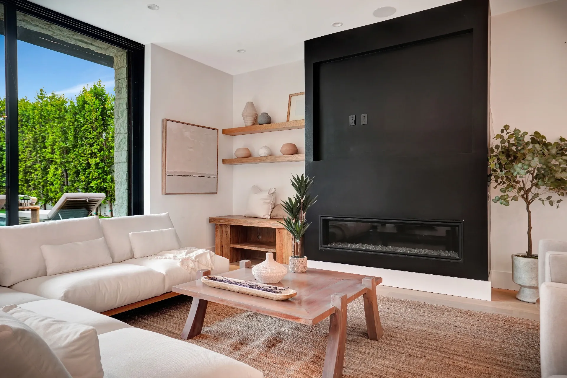 15602 Morrison St — Living Areas: 15602 Morrison St — Living room with white sectional, black linear fireplace, wood coffee table, and floor-to-ceiling windows