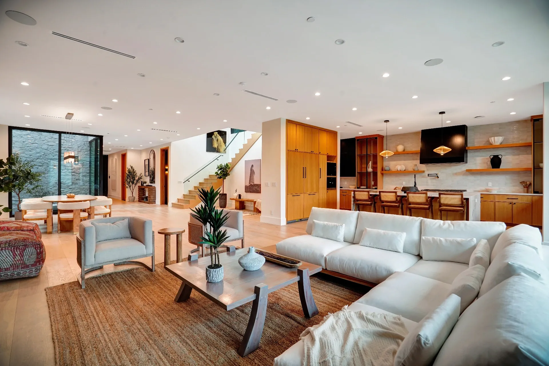 15602 Morrison St — Living Areas: 15602 Morrison St — Great room with white sectional sofa, wood dining table, contemporary chandelier, and kitchen integration