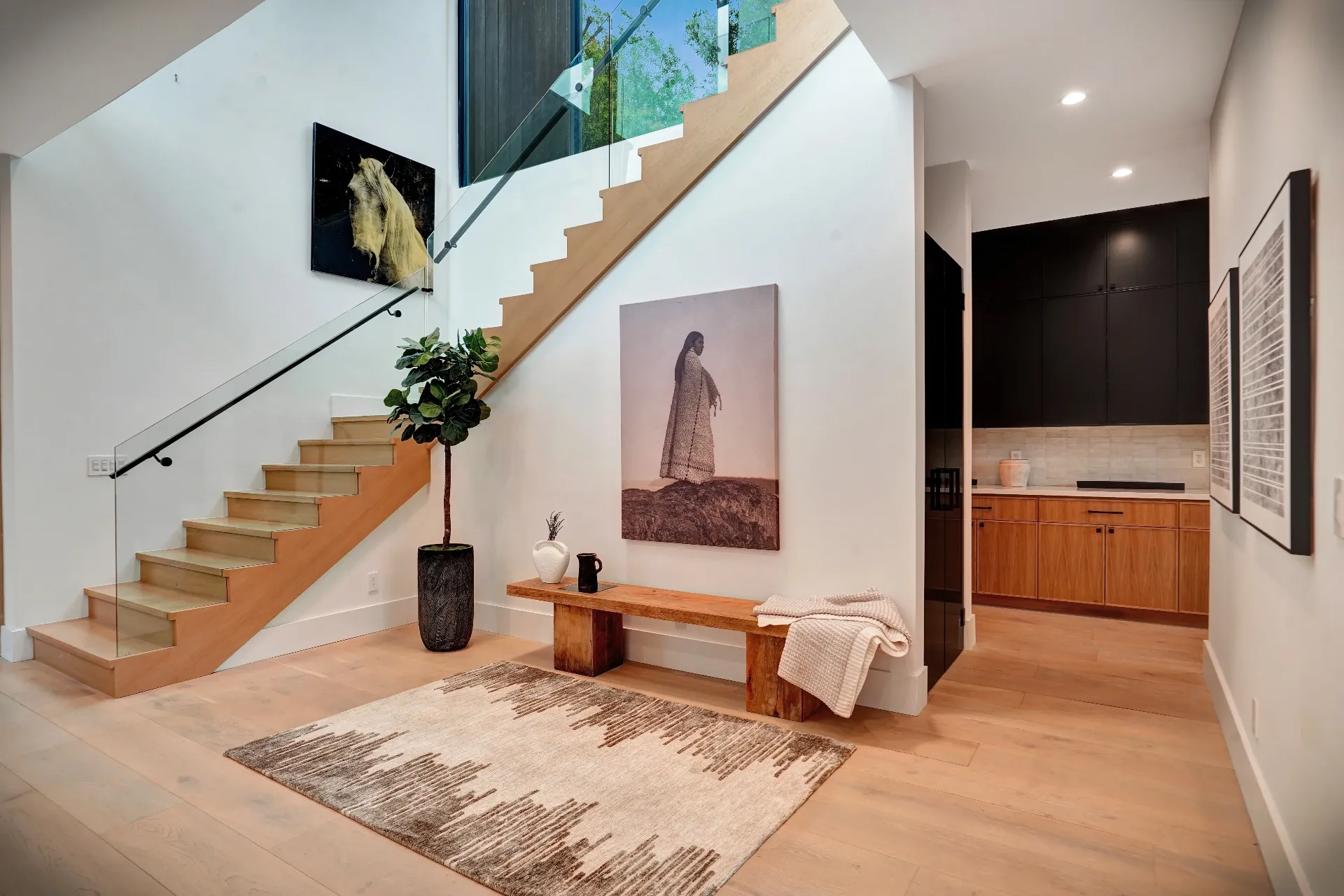 15602 Morrison St — Living Areas: 15602 Morrison St — Entry area with floating staircase, wood bench, contemporary art, and open concept design