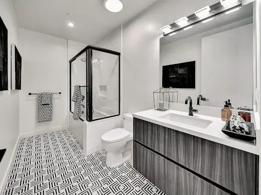 124 S Croft Ave — Bathrooms: Guest bathroom with geometric floor tile and wood vanity